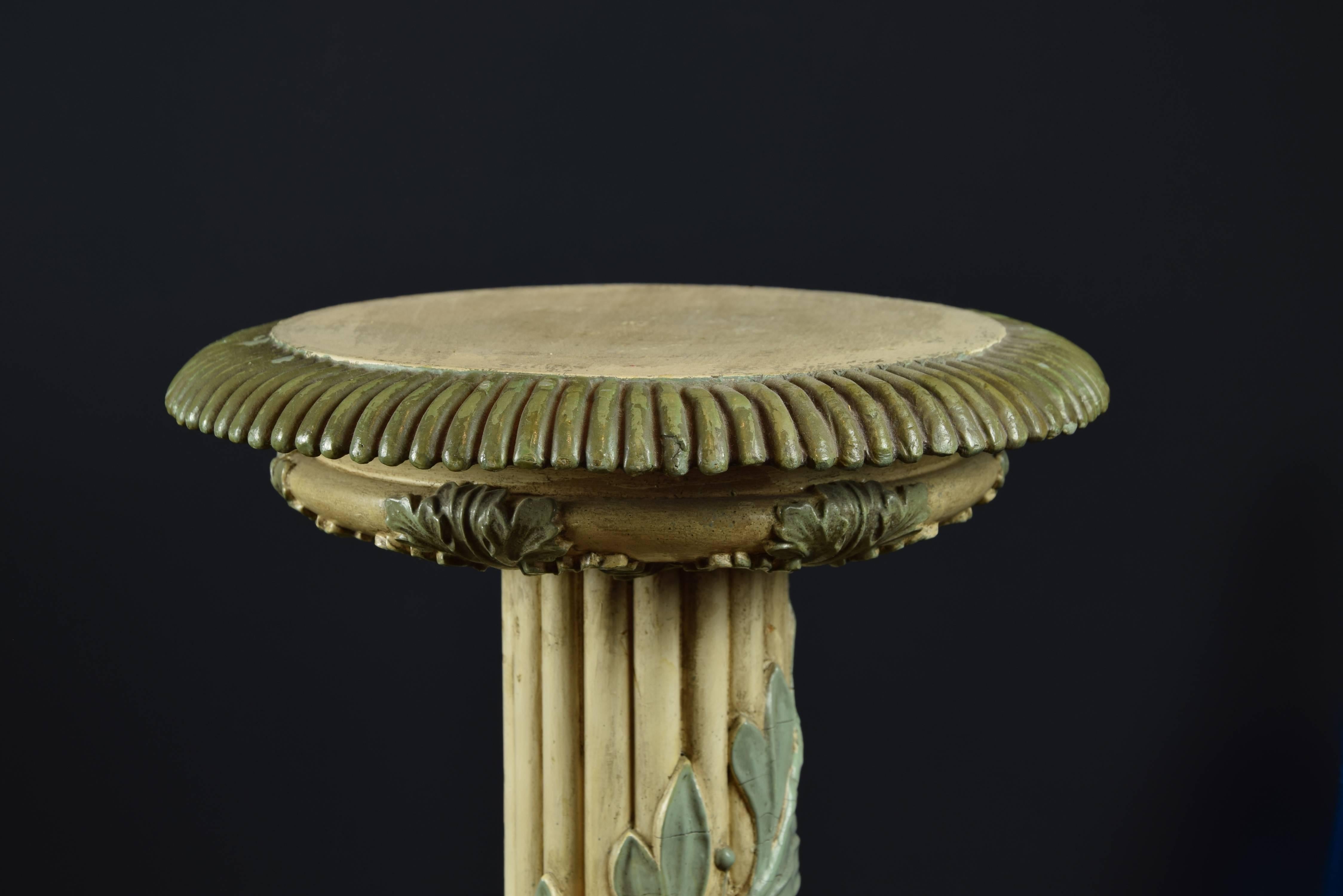 Pair of pedestals formed by a base elevated on lion claws with scrolls and birds, and a grooved shaft that ends in two circular moldings, decorated with plant and architectural elements. Spiral leaf branches have been carved on the shafts of the