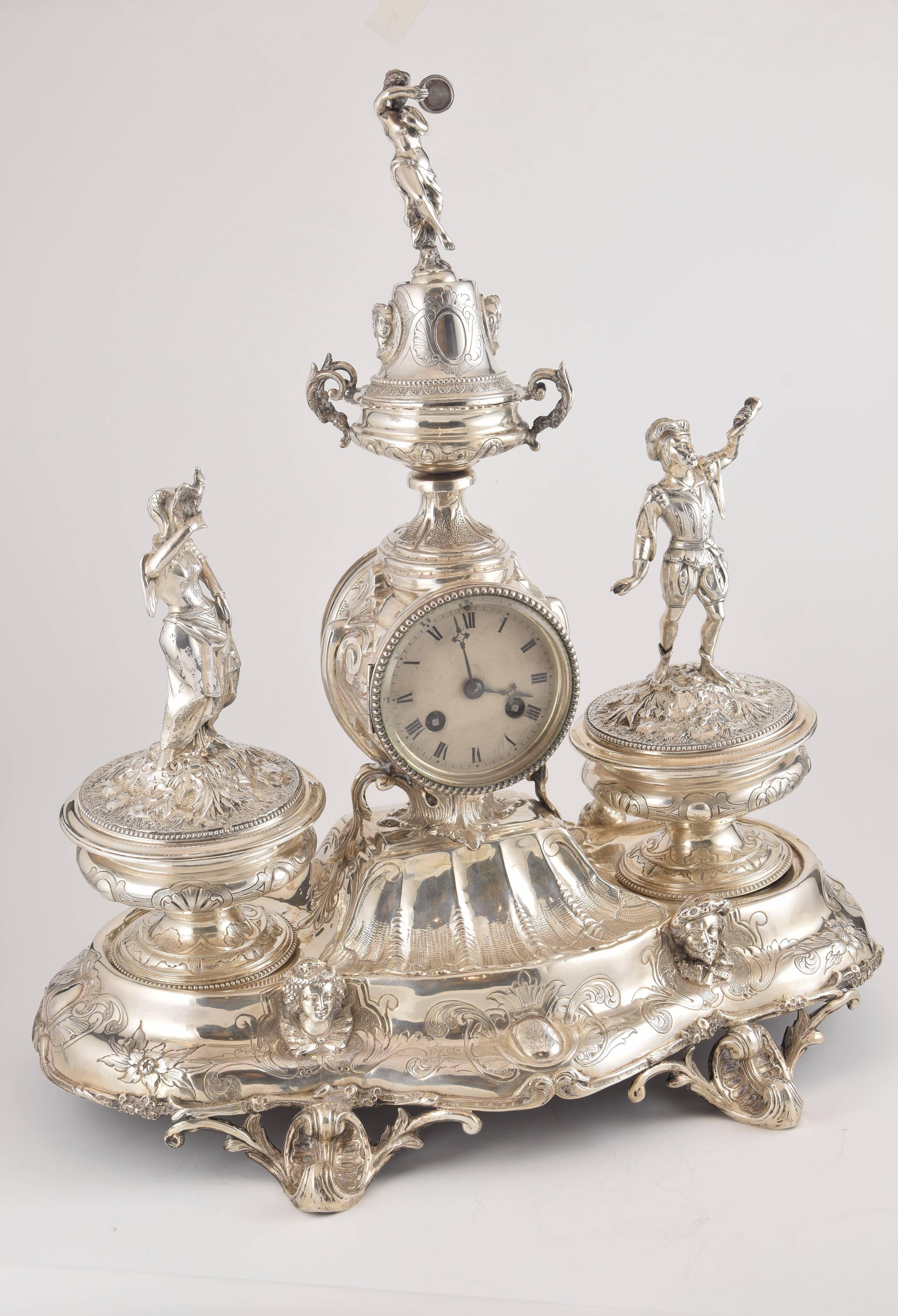 Solid silver writing set with clock. France, 19th century.
With hallmarks.
Writing set enhanced by a base slightly elevated by pieces decorated with stems and volutes with motifs that show Rococo influence. The front of this lower area, curved