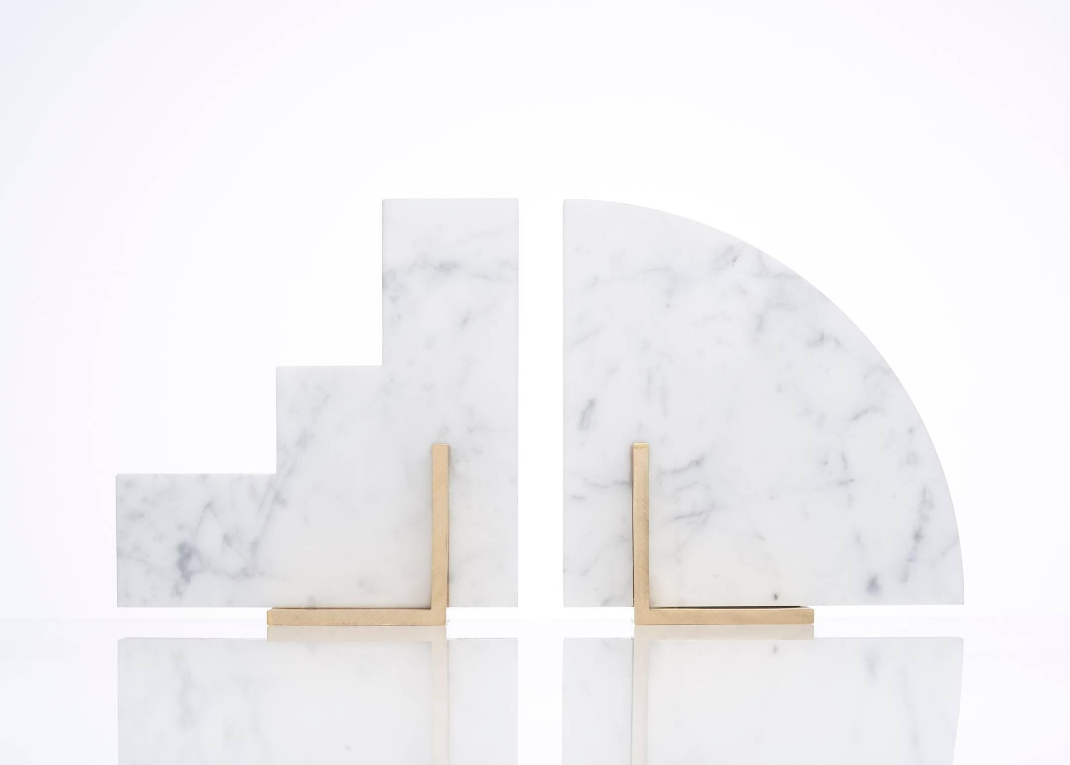 Meet Curvy and Steppy; the two individual bookends which as a pair are known as The Odd Couple Bookends.
Here shown in a honed Italian Carrara marble and a brushed brass base.
The marble cut into two geometric shapes and balanced over a brass
