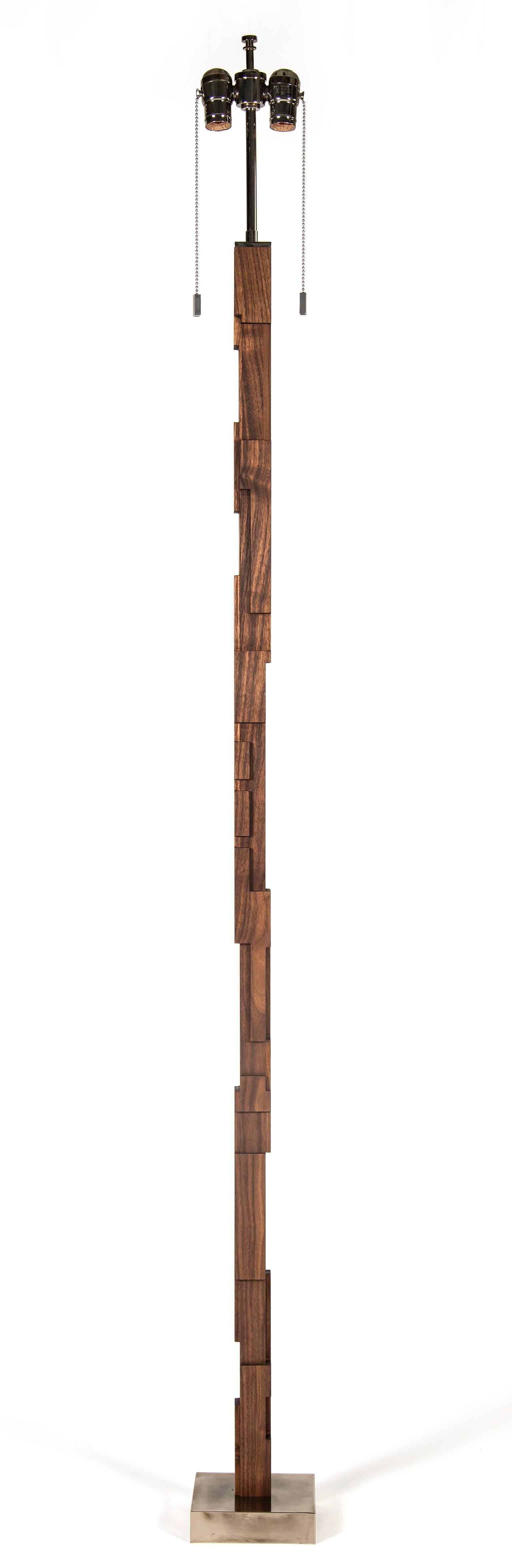 The Glyph floor lamp design is influenced by several styles and motifs such as the iconic Frank Lloyd Wright textile blocks of 'La Miniatura'-The Millard House as well as 'soft' Brutalist and Bauhaus aspects. The Glyph lamp is shown in solid walnut