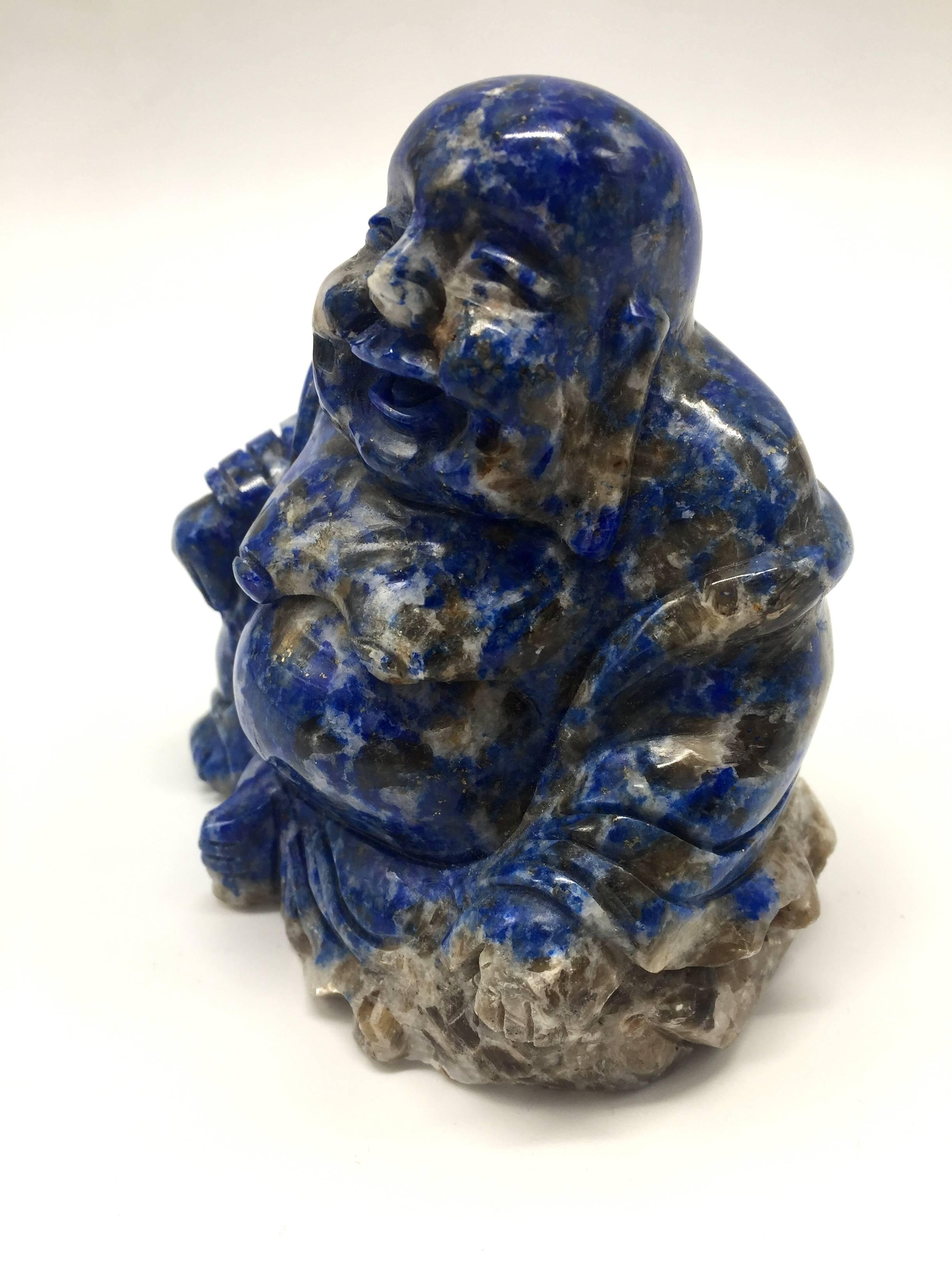 All natural Lapis happy Buddha, hand-carved. Besides the signature blue, this piece has beautiful glittering of gold. The great contrast of the gold against the saturated blue has a stunning visual effect. 

One of a kind. Highly collectible gem