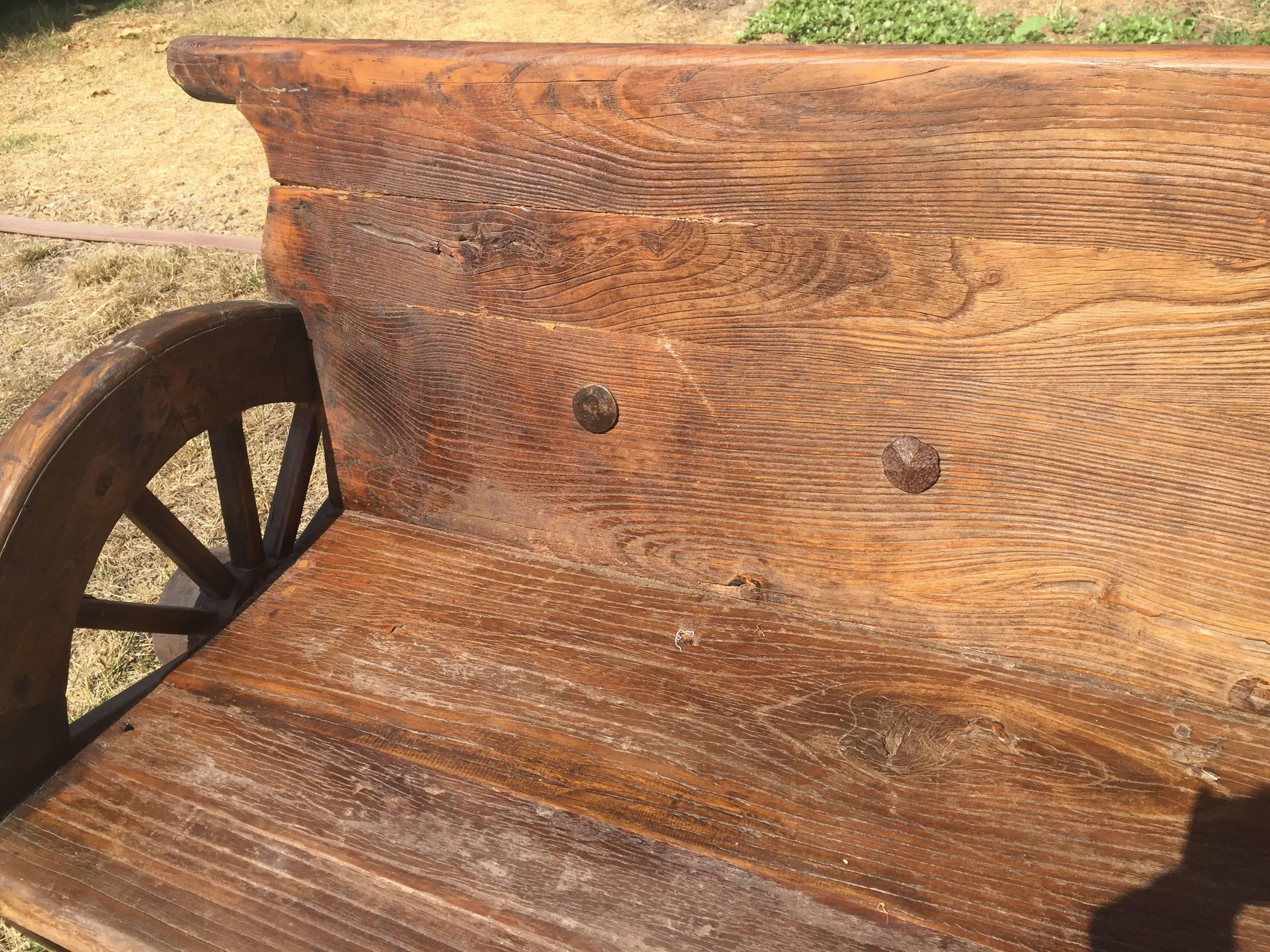 19th Century Rustic Bench with Antique Wheels and Iron Studs