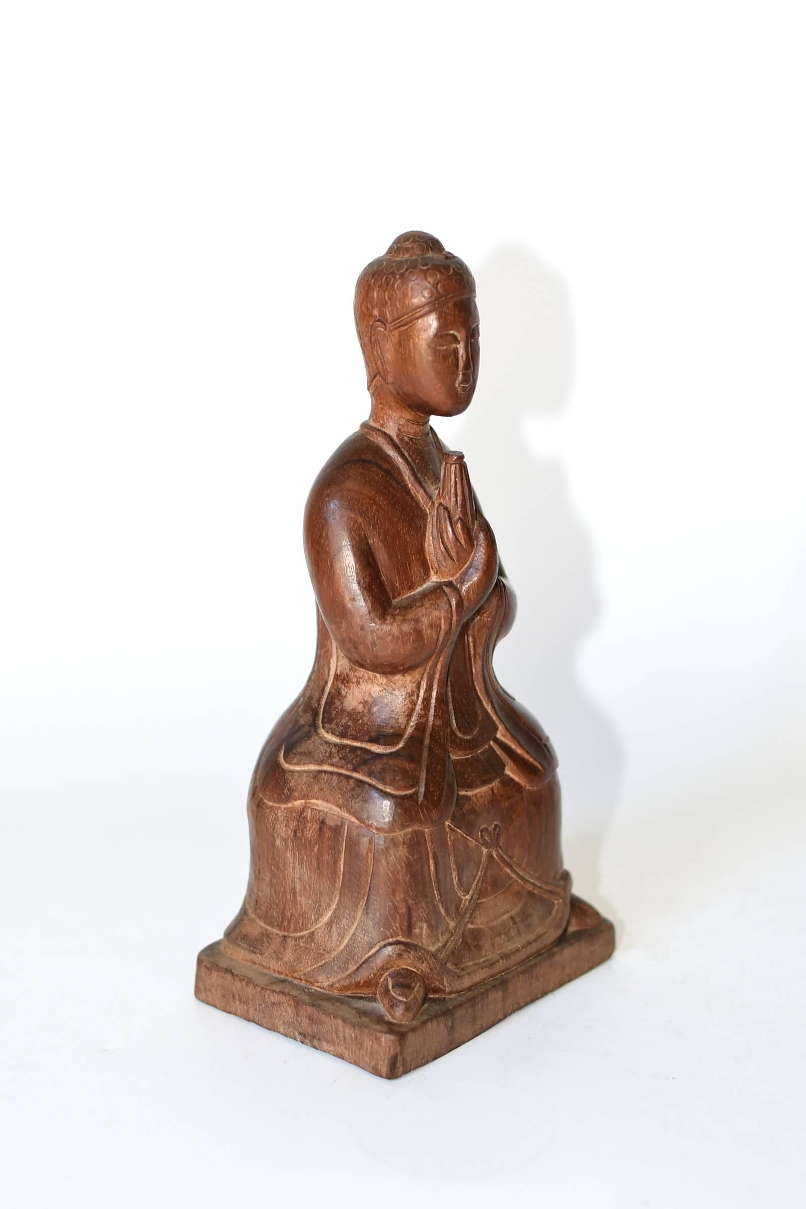 A fine carved Burmese Buddha. The wood used is the prized SE Asian rosewood, with its beautiful grains with thin ebony stripes. The artist captures Buddha's peaceful expression. The depiction of overlapped hands has a resemblance to the lotus