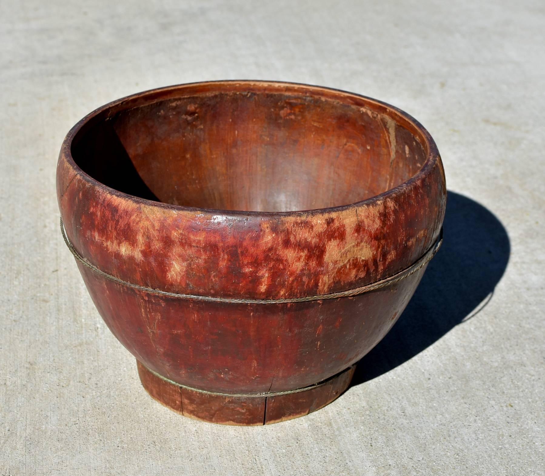 A simple antique bucket. It is hand made with solid wood, held in tension with brass ropes. Such a bucket serves many purposes. It can be used as a planter, or a hold-it-all. Original maker's mark at the bottom.