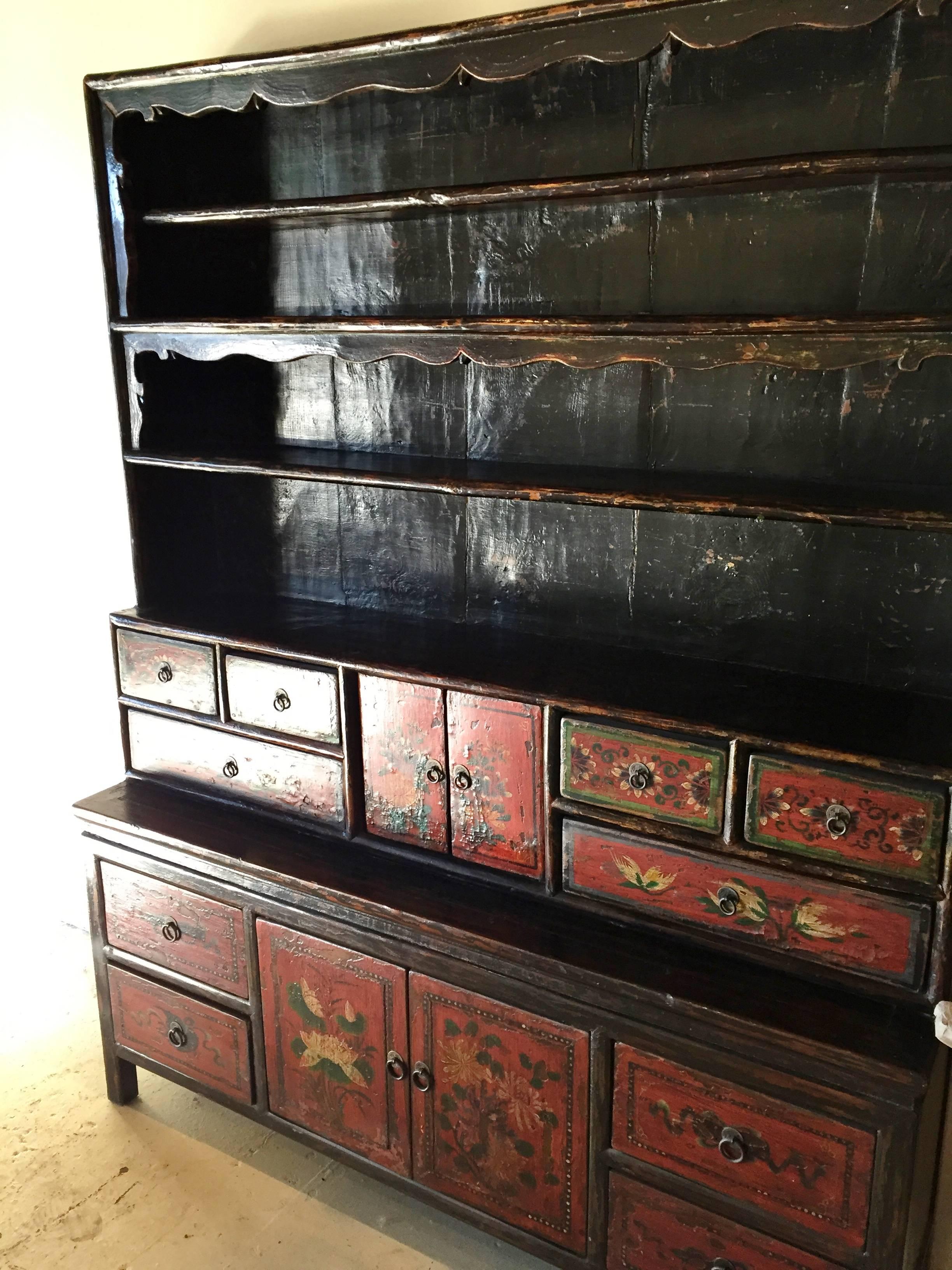Rare 19th century Tibetan cupboard has multiple tiers of display and storage. The top is of an open design with scrolled framework. The middle section features six drawers and one pair of doors, while the bottom section four larger drawers and