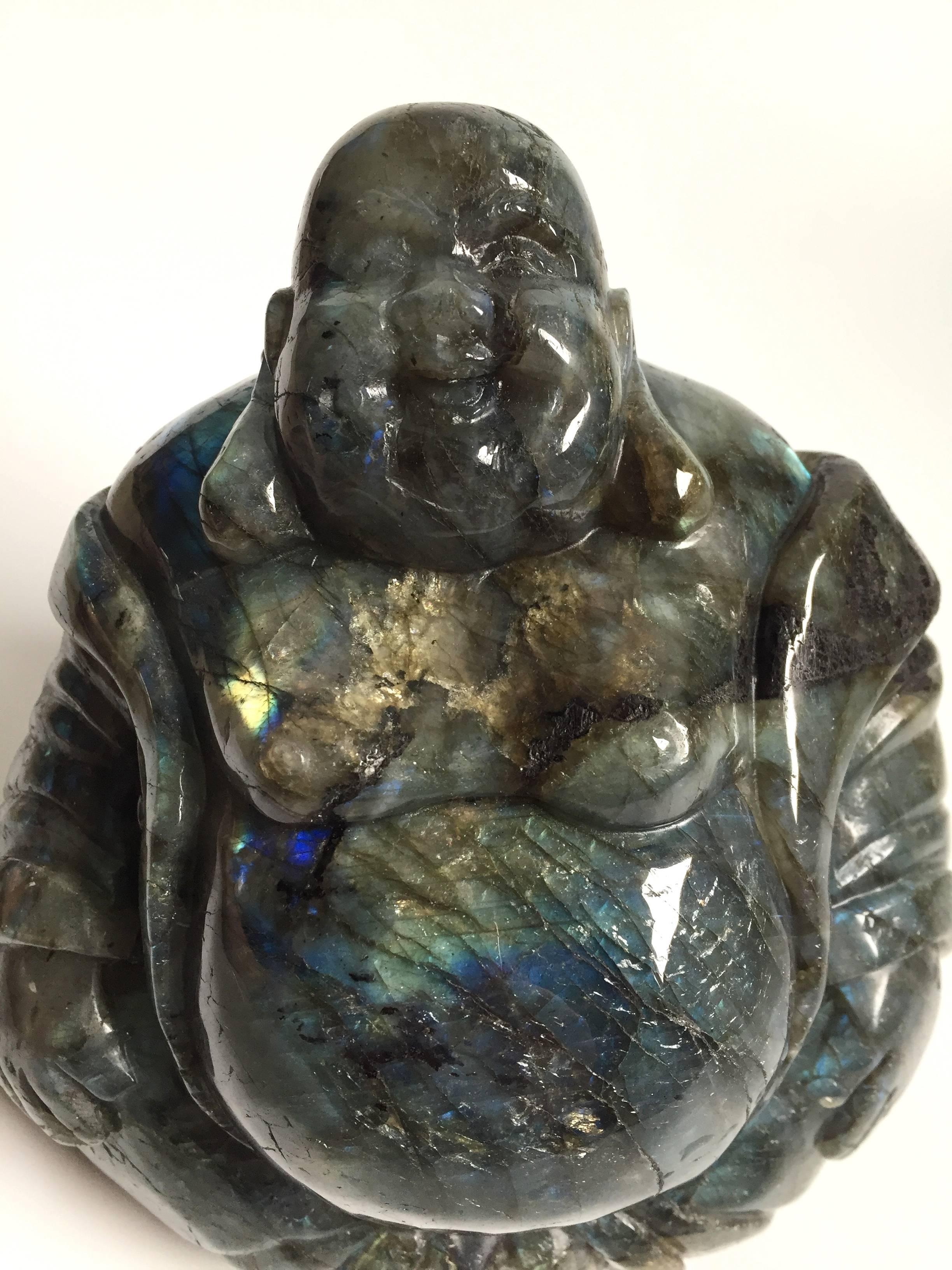 A fantastic labradorite Happy Buddha statue. The Buddha with round face, long earlobes and broad smile, wearing a loose robe that exposes the front of his bodice, a signature look of the worry free Happy Buddha. This spectacular piece is craved from