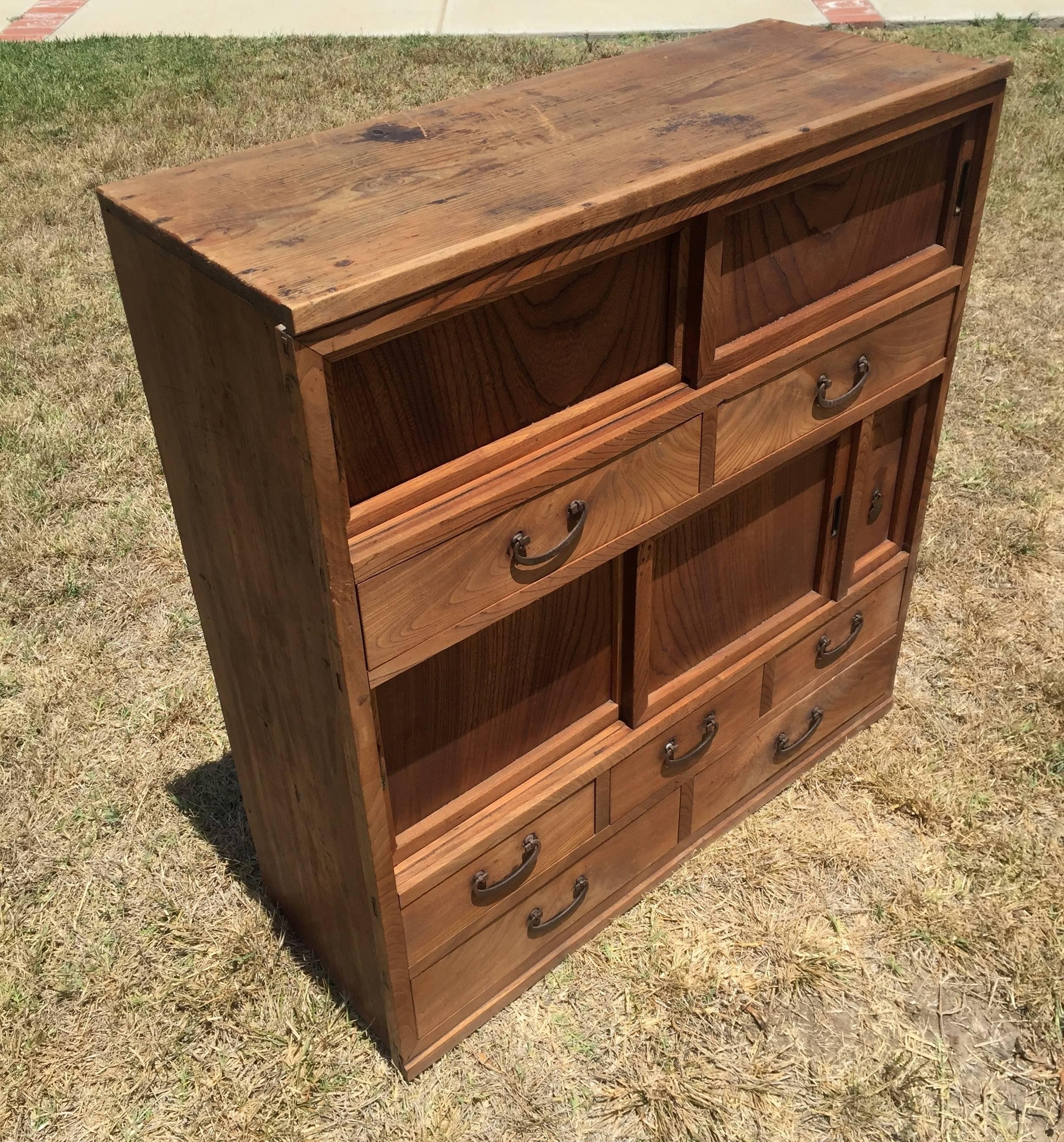 Beautiful Japanese Tansu chest features seven full length drawers and two sets of sliding doors. Solid elmwood have graceful swirling grains. All iron hardware original to the piece.

A great piece for any interior, especially a natural, rustic or