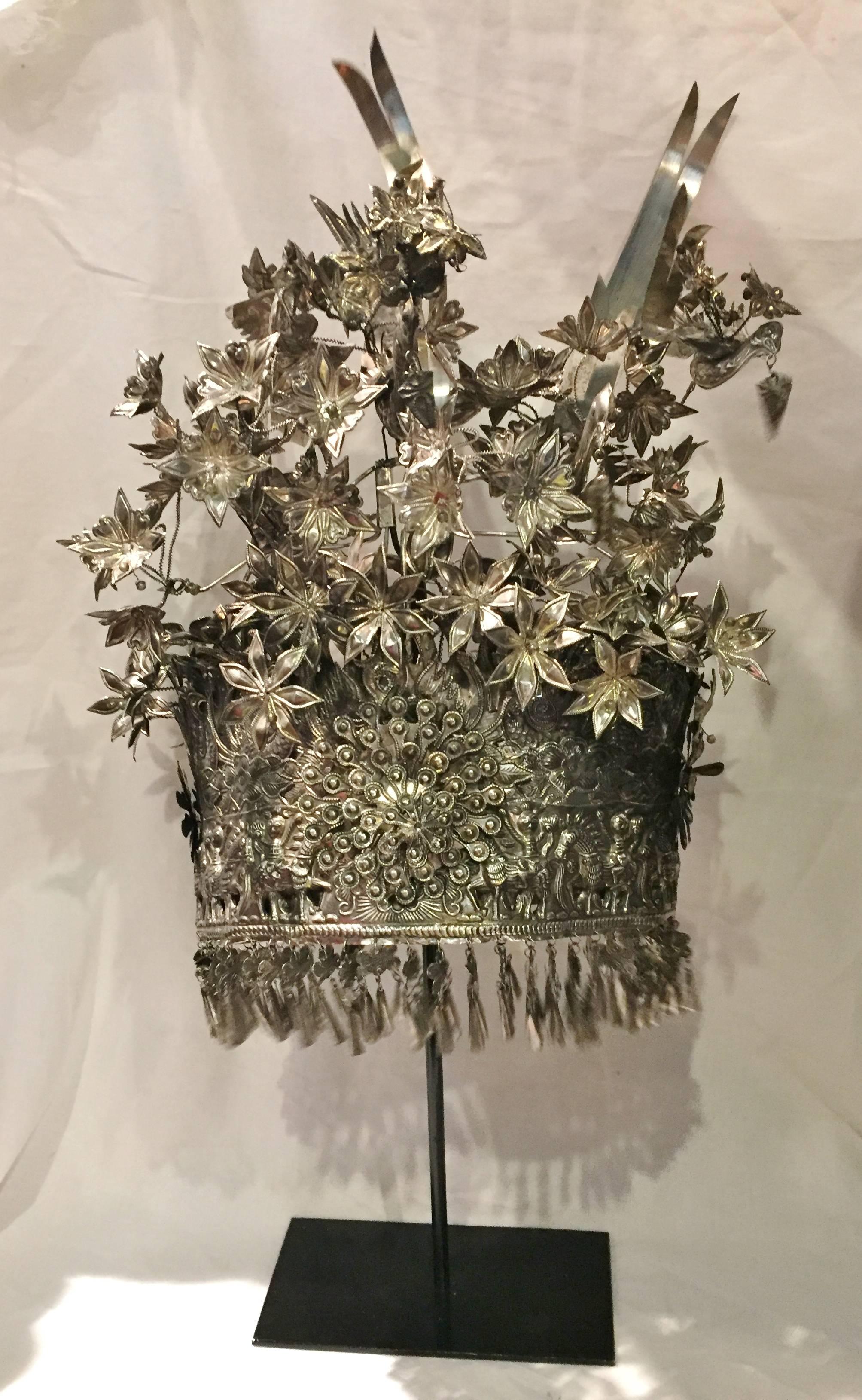 This exquisite crown is a bridal head dress from the Chinese Miao Tribe. Featuring a central medallion of a five-layer peony, the crown is elaborately decorated with over 60 lilies. They symbolize marital bliss. Other important motifs are phoenixes,