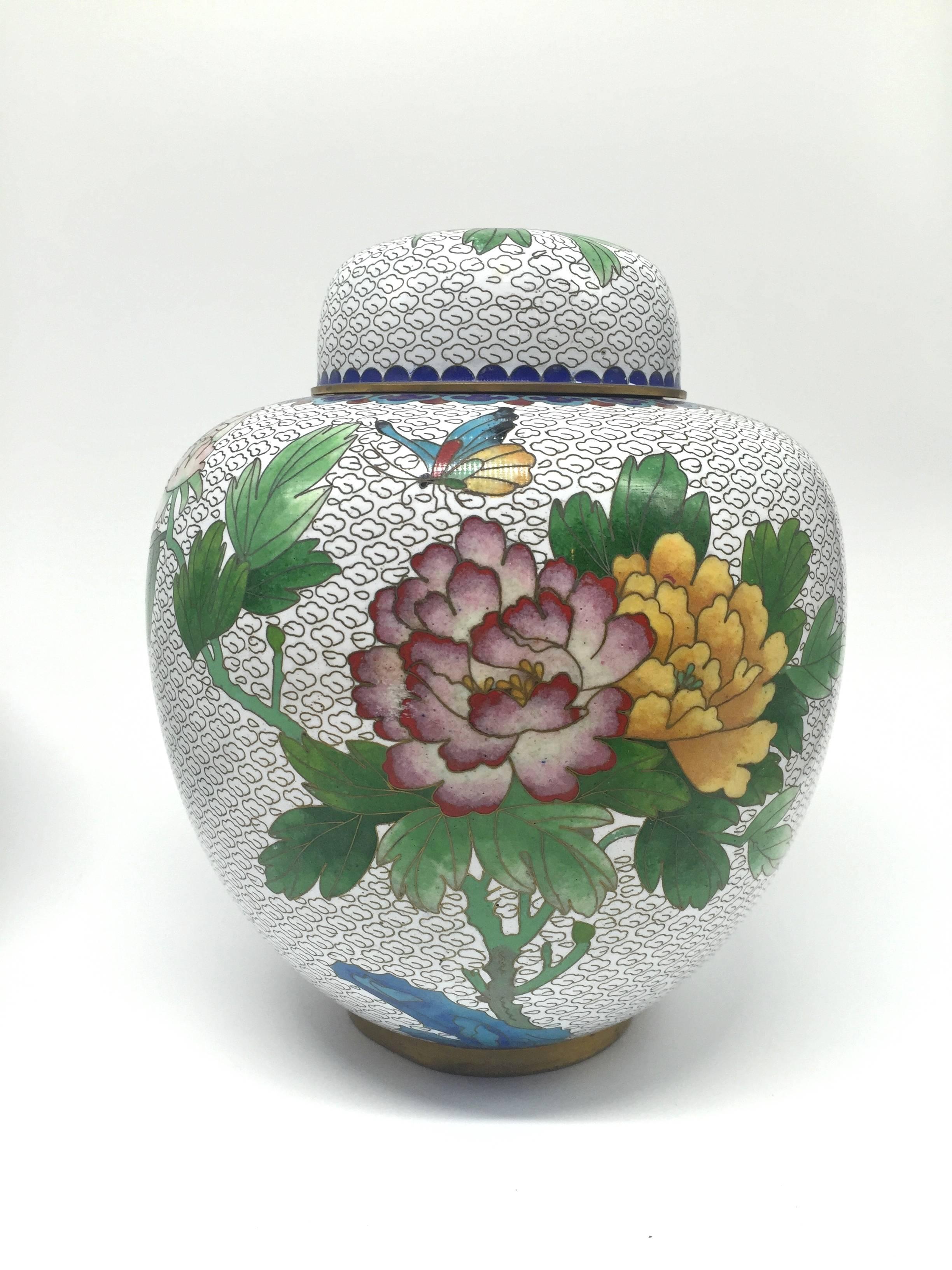 Beautiful white cloisonné jars feature burgundy and saffron colored peonies. The images are created with marbles inlaid within Fine brass wires. Peonies are symbols of prosperity. The craftsmanship is very fine. The color combination is very