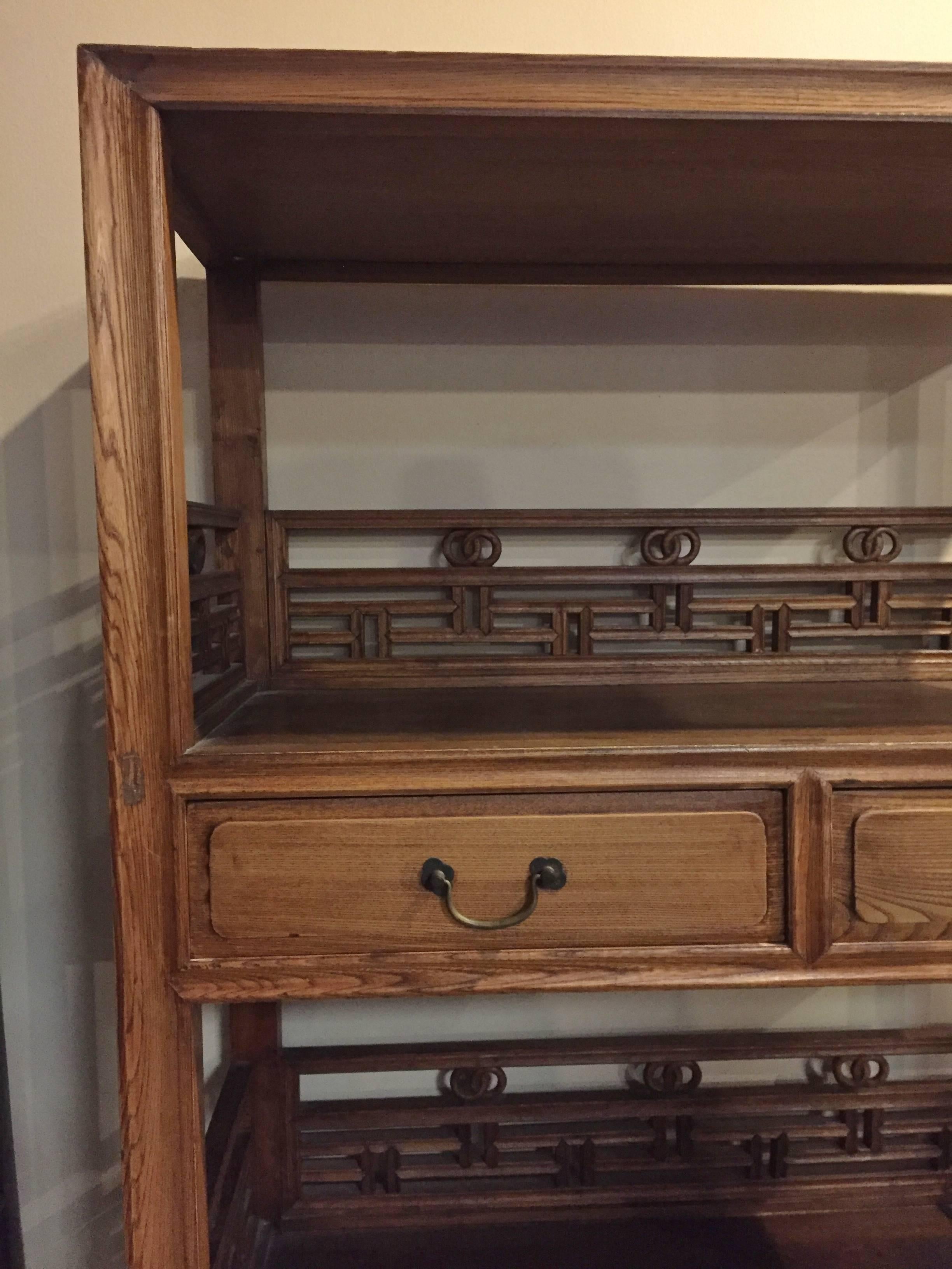 A pair of elegant Chinese bookcase. 

The solid wood bookcase has an open design with three levels and two drawers. Beautiful rings and lattice work decorate the pieces adding more visual interest. Choice elmwood was chosen for the bookcase.
