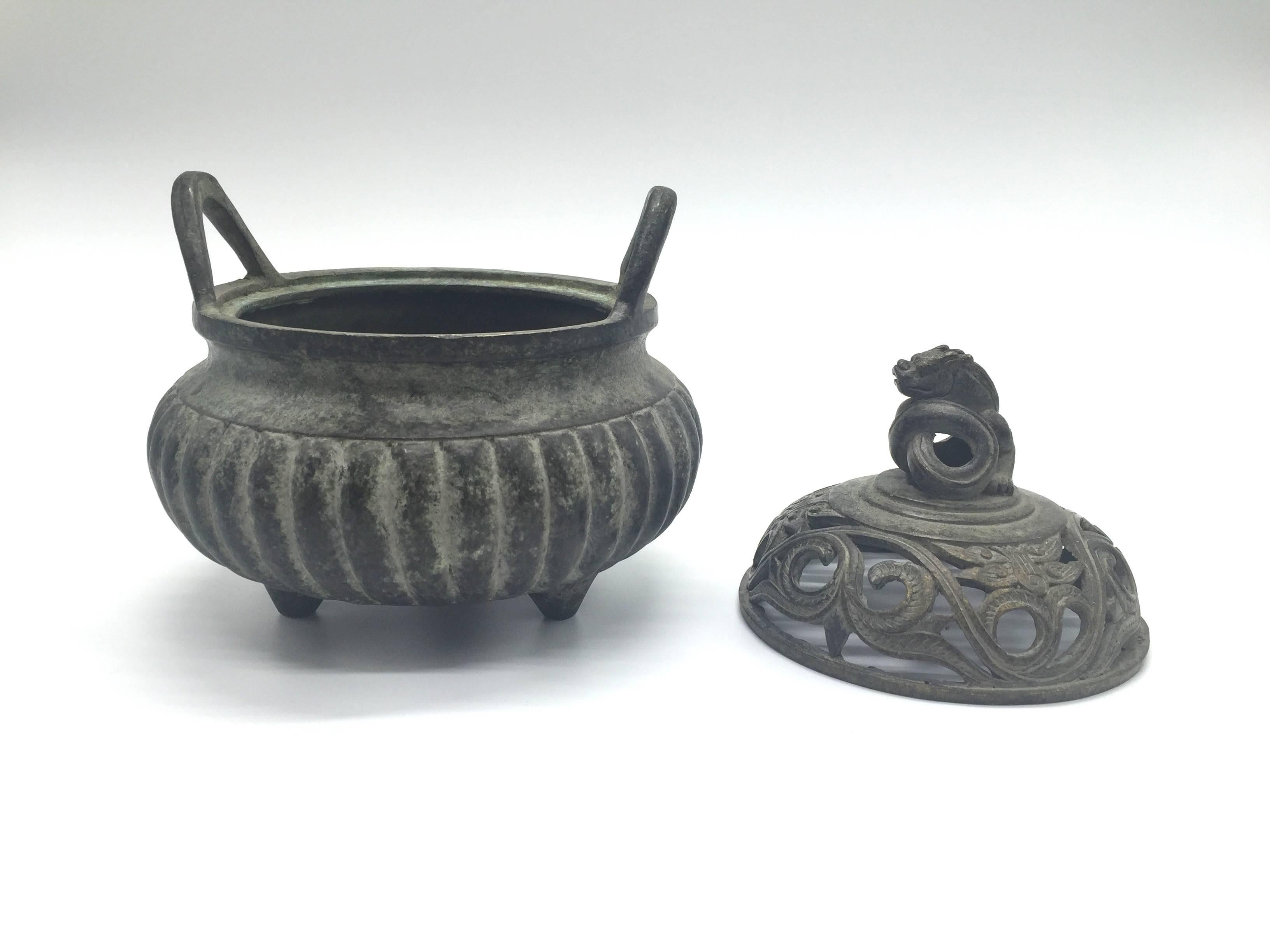Exquisite Ming Xuan De style incense burner features a coiled dragon as finial and a melon bodice. The lid has open work with the motif of beasts, an ancient symbol for power and good luck. The traditional 3-foot design is typical of Ming style. It