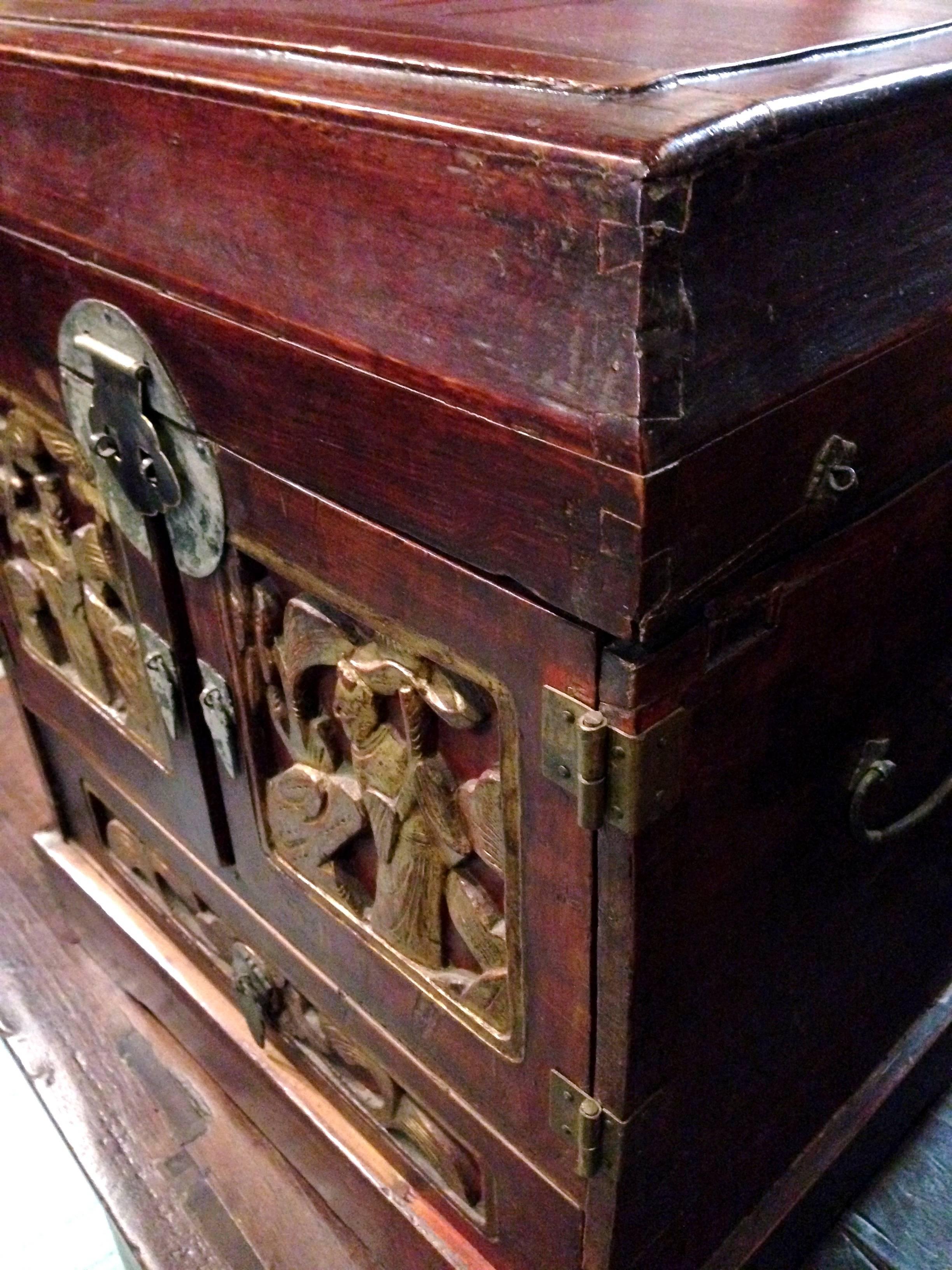 Beautiful 19th century jewelry box features four drawers and a space under the lid for storage. The most interesting is the tiny locking peg that discreetly locks the bottom drawer. Carved Harmony Gods on the doors symbolize peace and happiness.