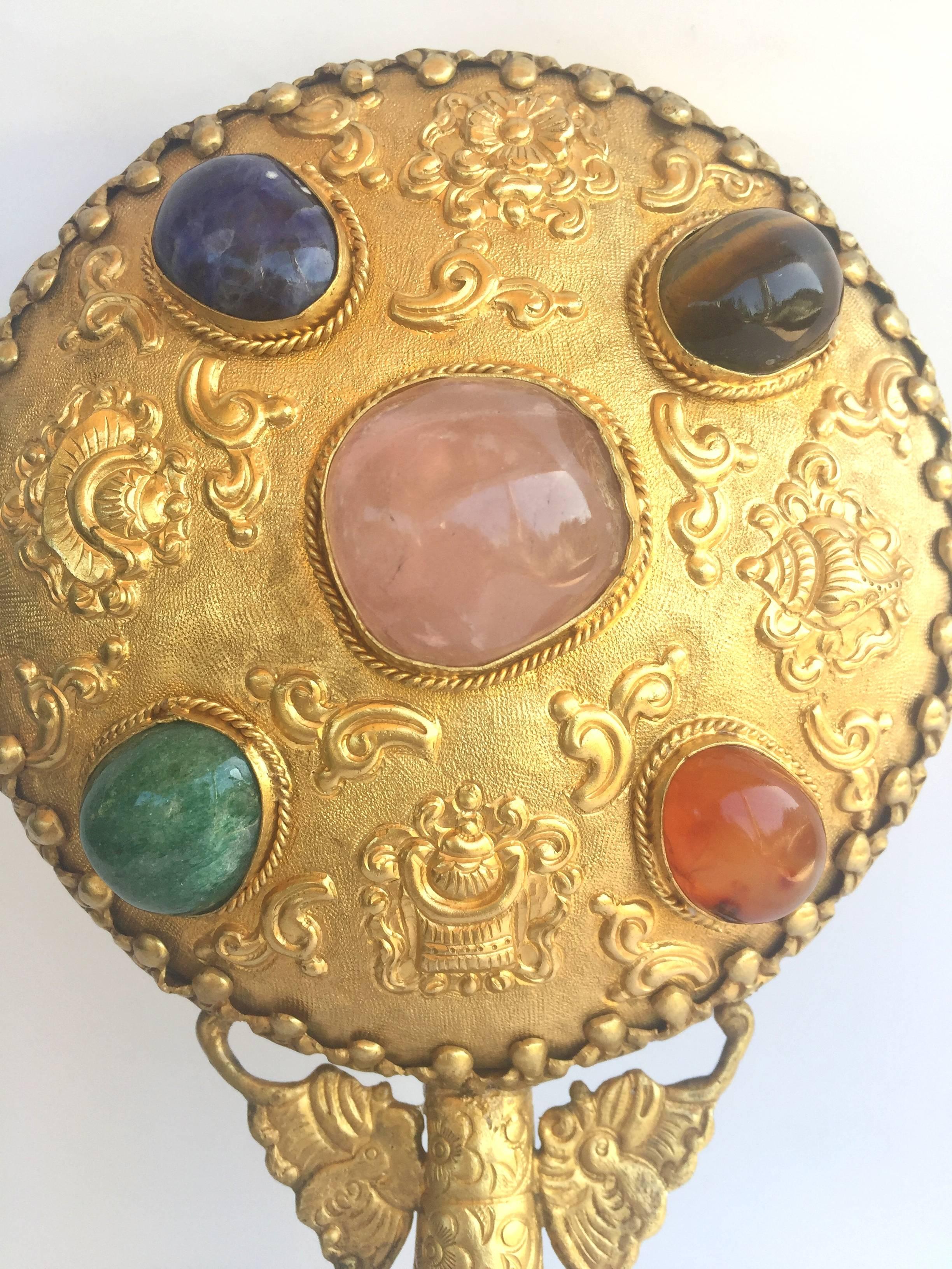 Fantastic mirror engraved with gilded flowers and treasure pots is adorned with 5 very large gem stones of rose quartz, tiger eye, lapis, carnelian and aventurine. The part that connects to the handle forms a butterfly, further enhancing the beauty