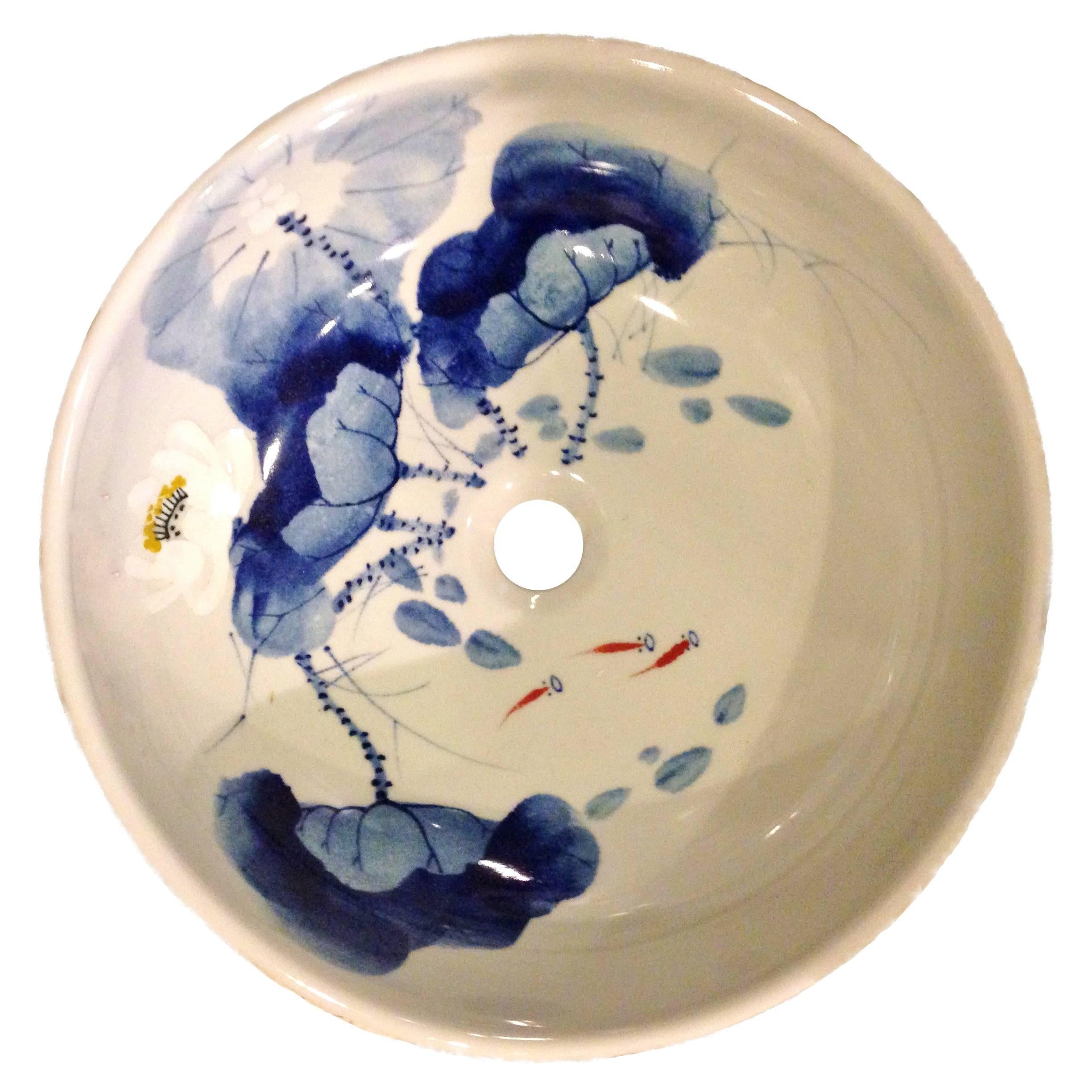 This pair of beautiful sinks are the only pair that we have. Completely hand-painted, the bowls depict groups of fish swimming amid lotuses. The use of inky blue is a Classic Chinese watercolor approach. Details such as folds of the leaves, shrimps,