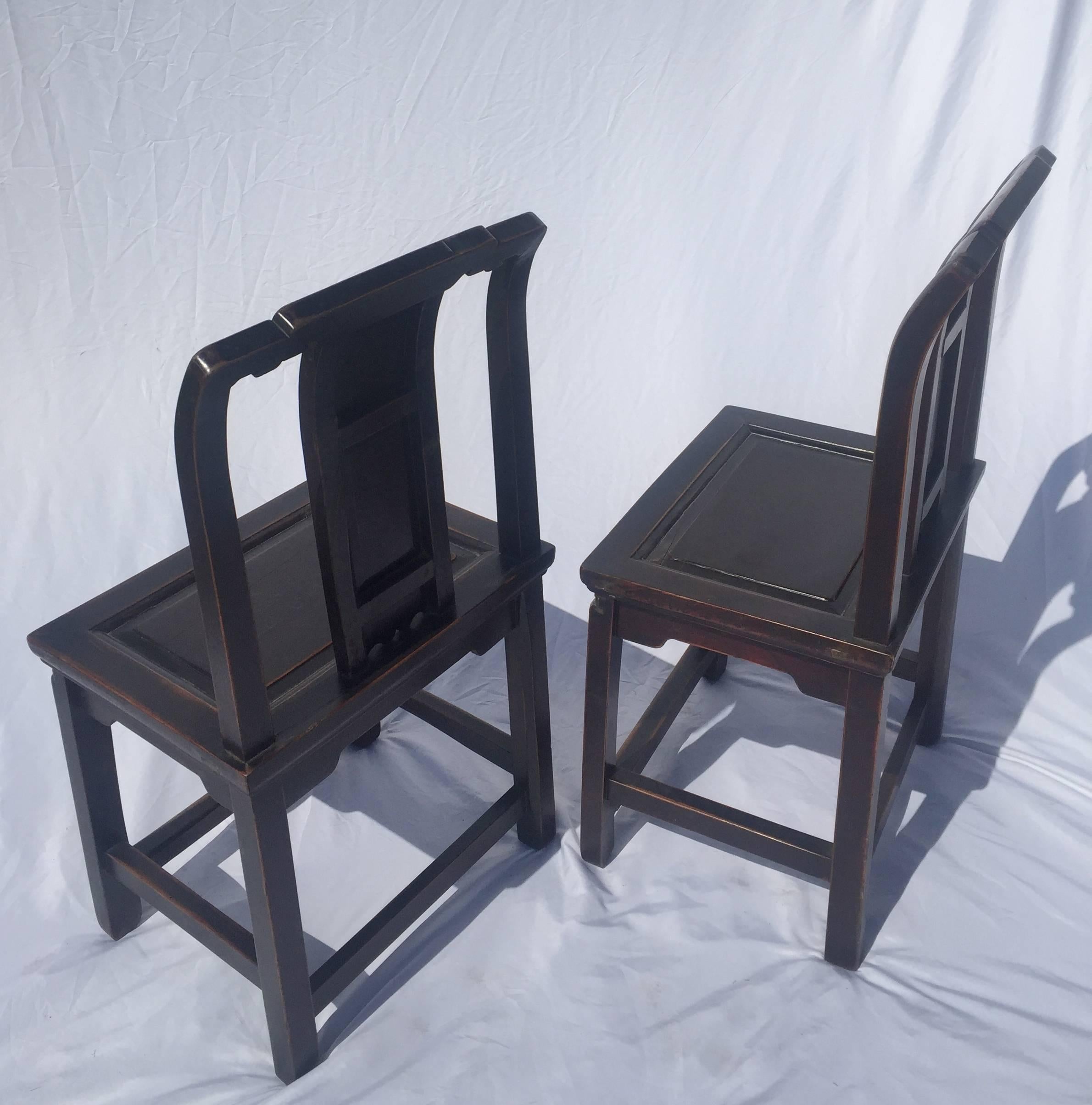 A pair of Chinese antique chairs in all original, remarkable condition.

The chairs have a traditional Southern Chinese style with slightly bent back splats and tiered top stretchers. A single symbol of longevity is carved on each of the back