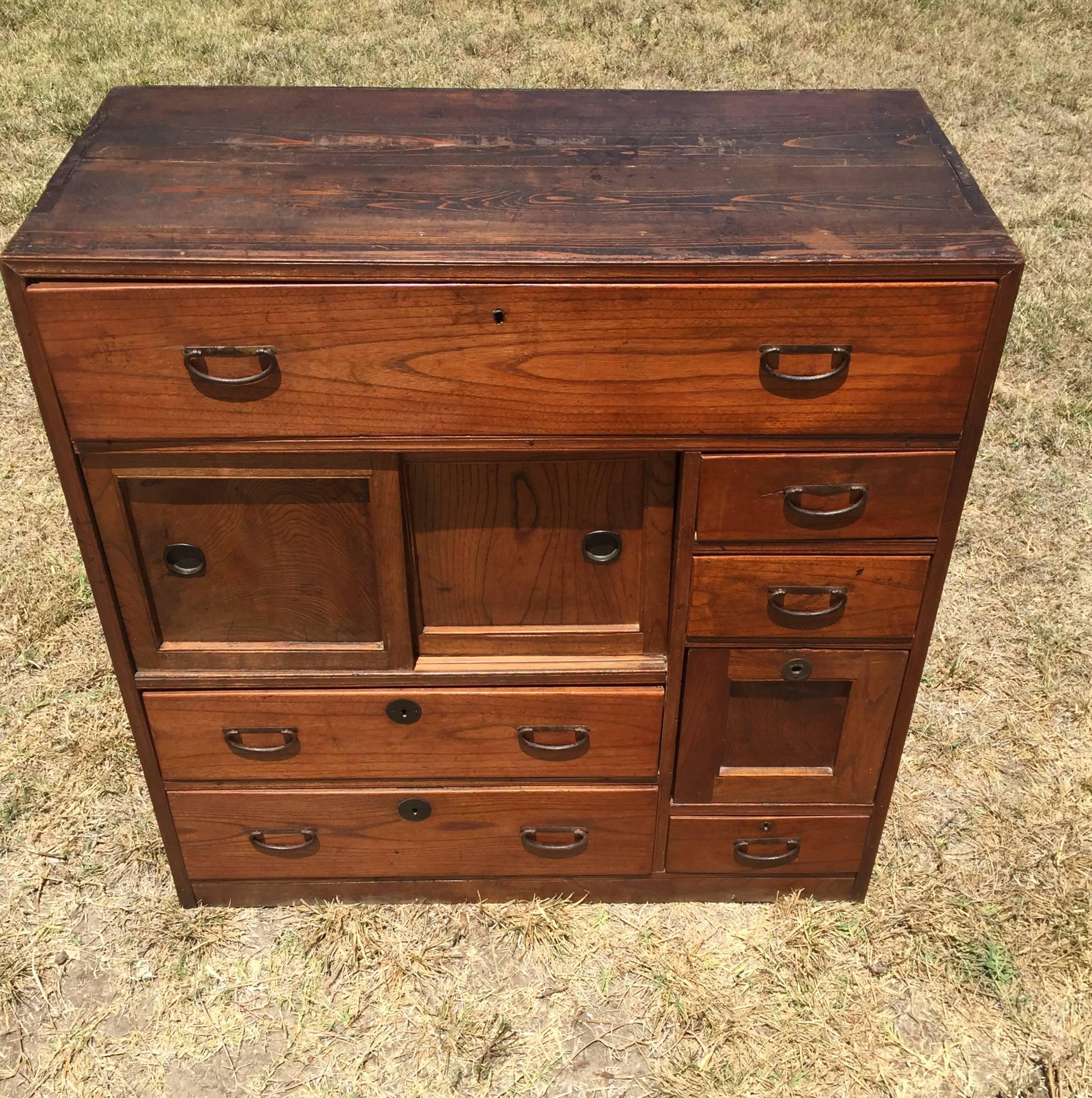 Beautiful vintage Japanese Tansu chest features eight drawers and sliding doors. Two Interior drawers behind a cover. Solid wood have graceful swirling grains. All hardware original to the piece.

A great piece for any interior, especially a