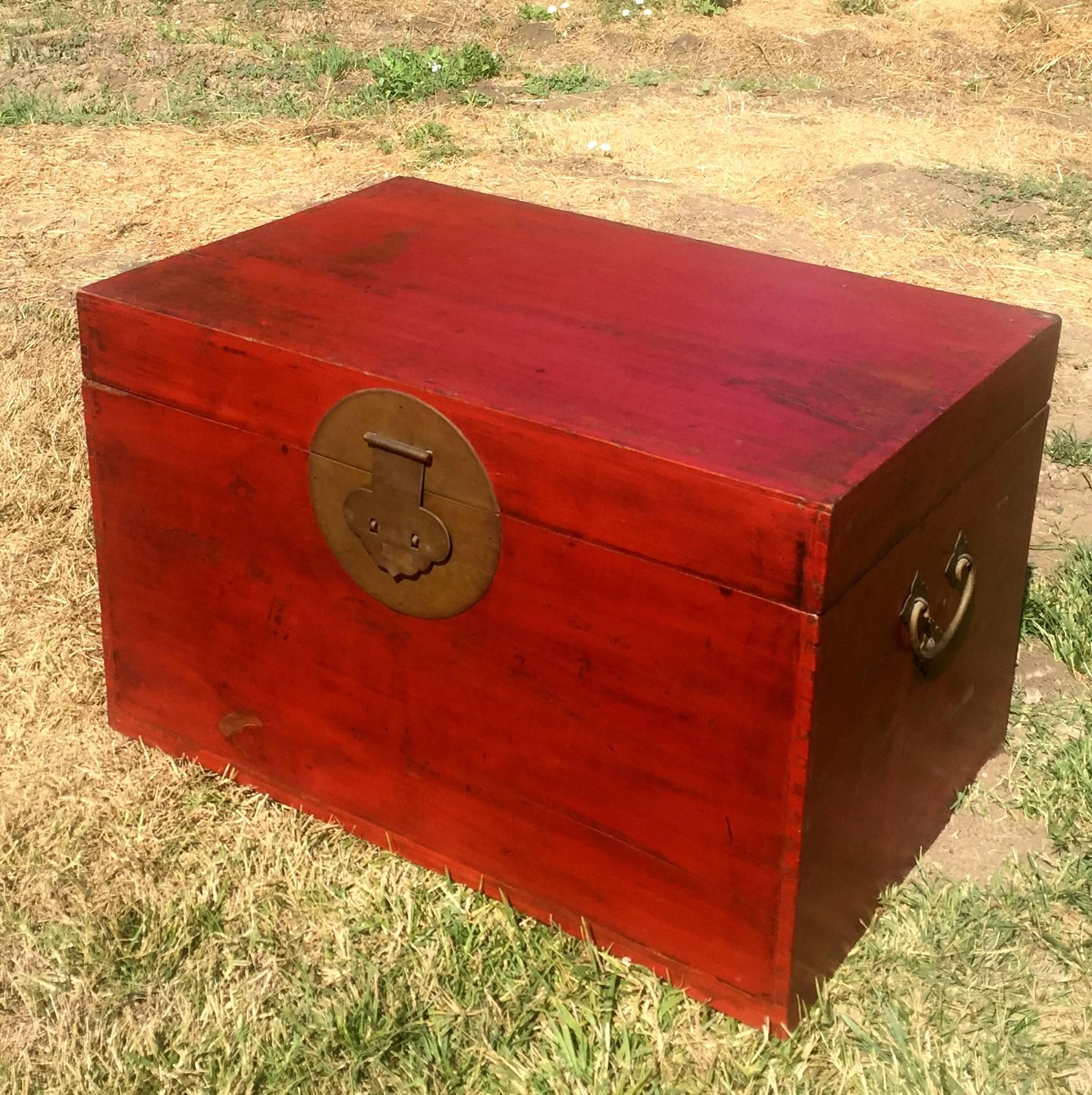 A beautiful Chinese Trunk in the color of red cinnabar. 

This wonderful piece is made of solid wood, using tenons and mortises and exquisite dovetails. The interior is large enough to store blankets. Simple stunning golden brass hardware