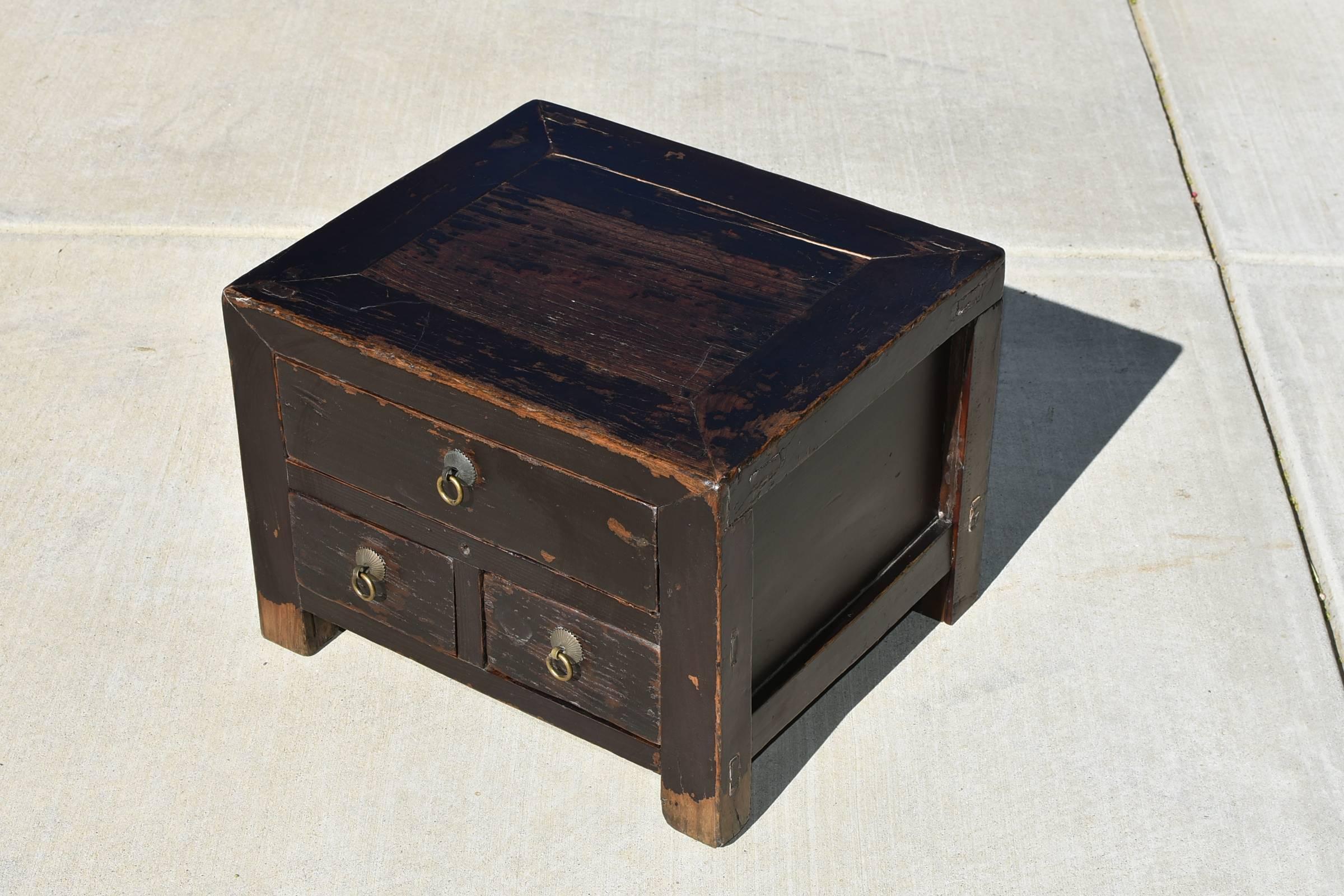 An antique Chinese chest, small but solid, very heavy and substantial.  This is a Northern Chinese piece that is used to store important items and placed near the bed. Three drawers keep things safe and near the owner.  All original. Solid wood.
