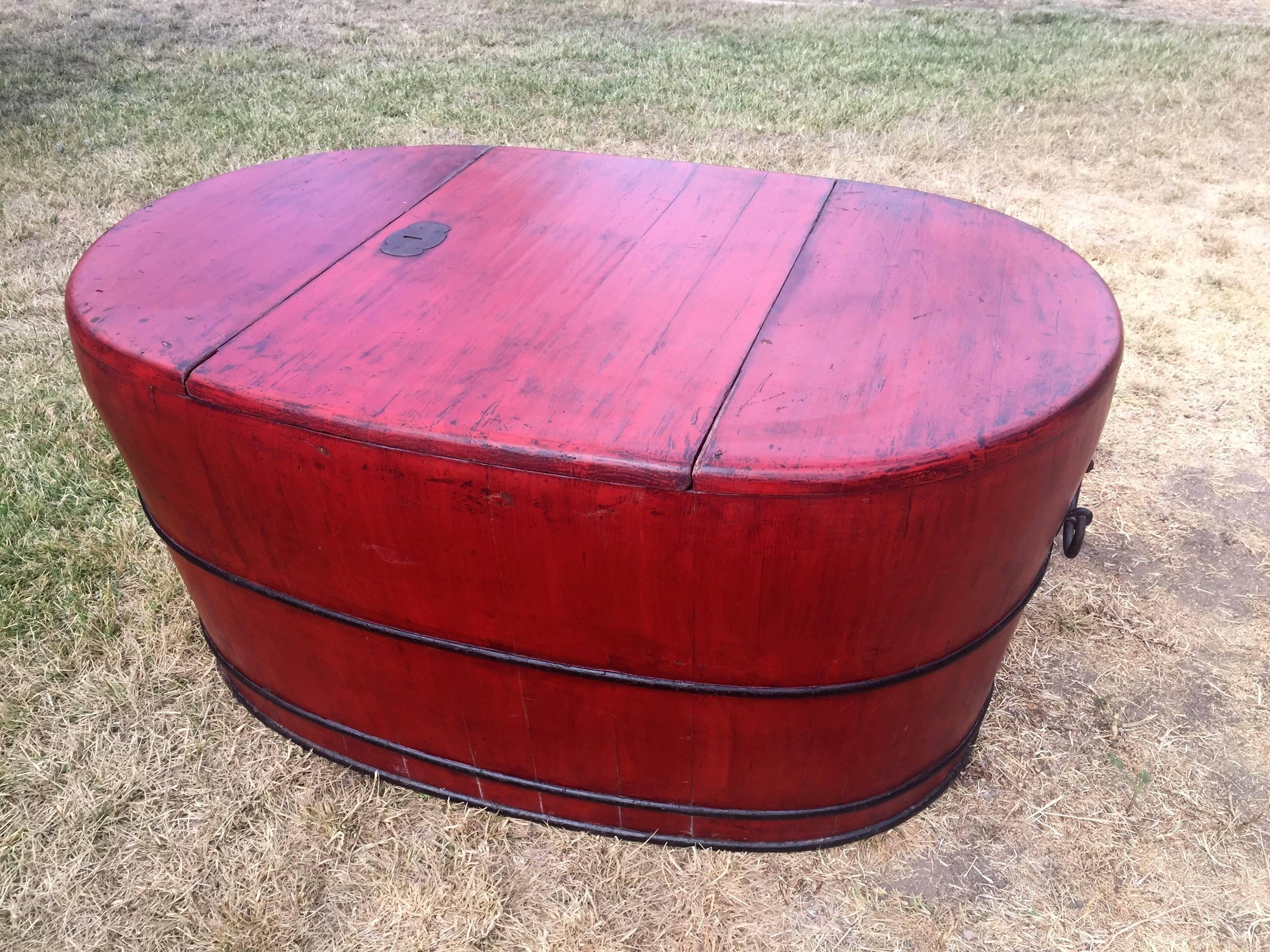 A solid wood red lacquered bath tub. This piece opens up in the middle to reveal a substantial space for soaking or storage. Interior in excellent condition. Red lacquer, an auspicious color for southern China, symbolizes good fortune. Beautiful