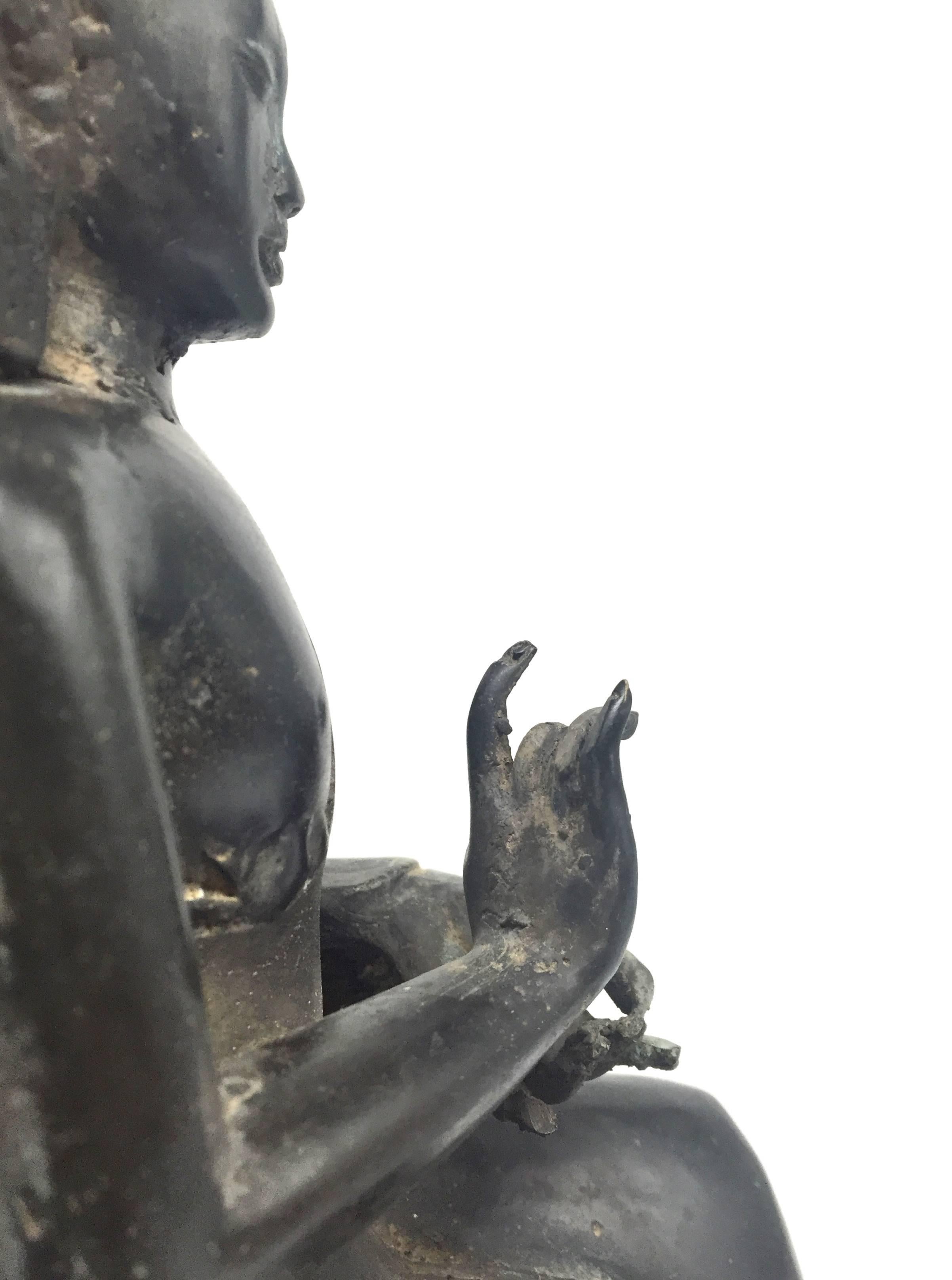 A fine 20th century Burmese bronze Buddha.

The Buddha is seated on a throne with two lions anchoring the base. His back features beasts and warriors with a halo above and behind. His ankles are together with a decorated sash draping down to meet