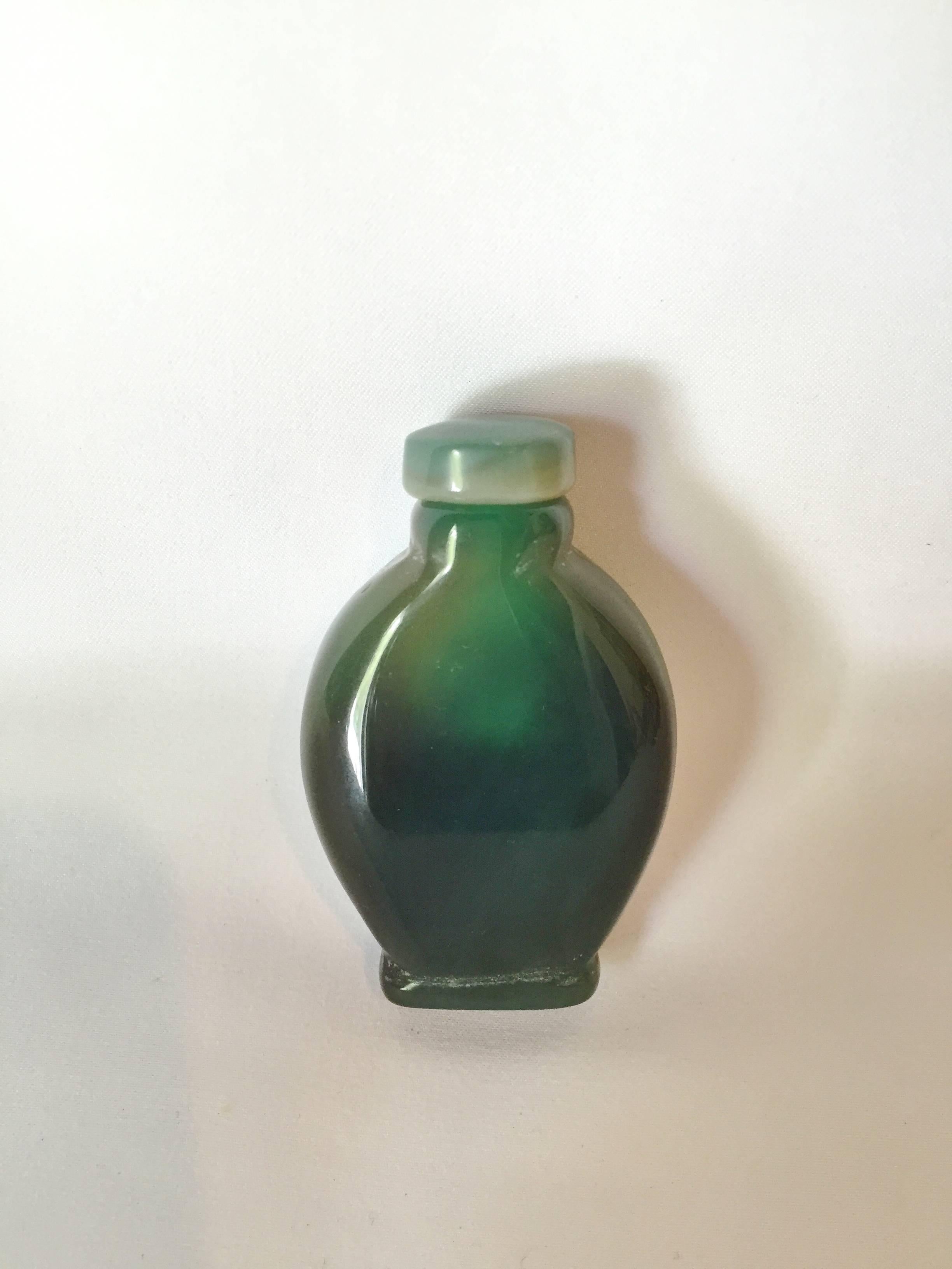 Stunning snuff bottle made with the most beautiful, rare, green chalcedony agate. The variations in the color are mysterious and very romantic. This is stone, not Peking class, with beautiful swirls of emerald colors. The stone turns grey and