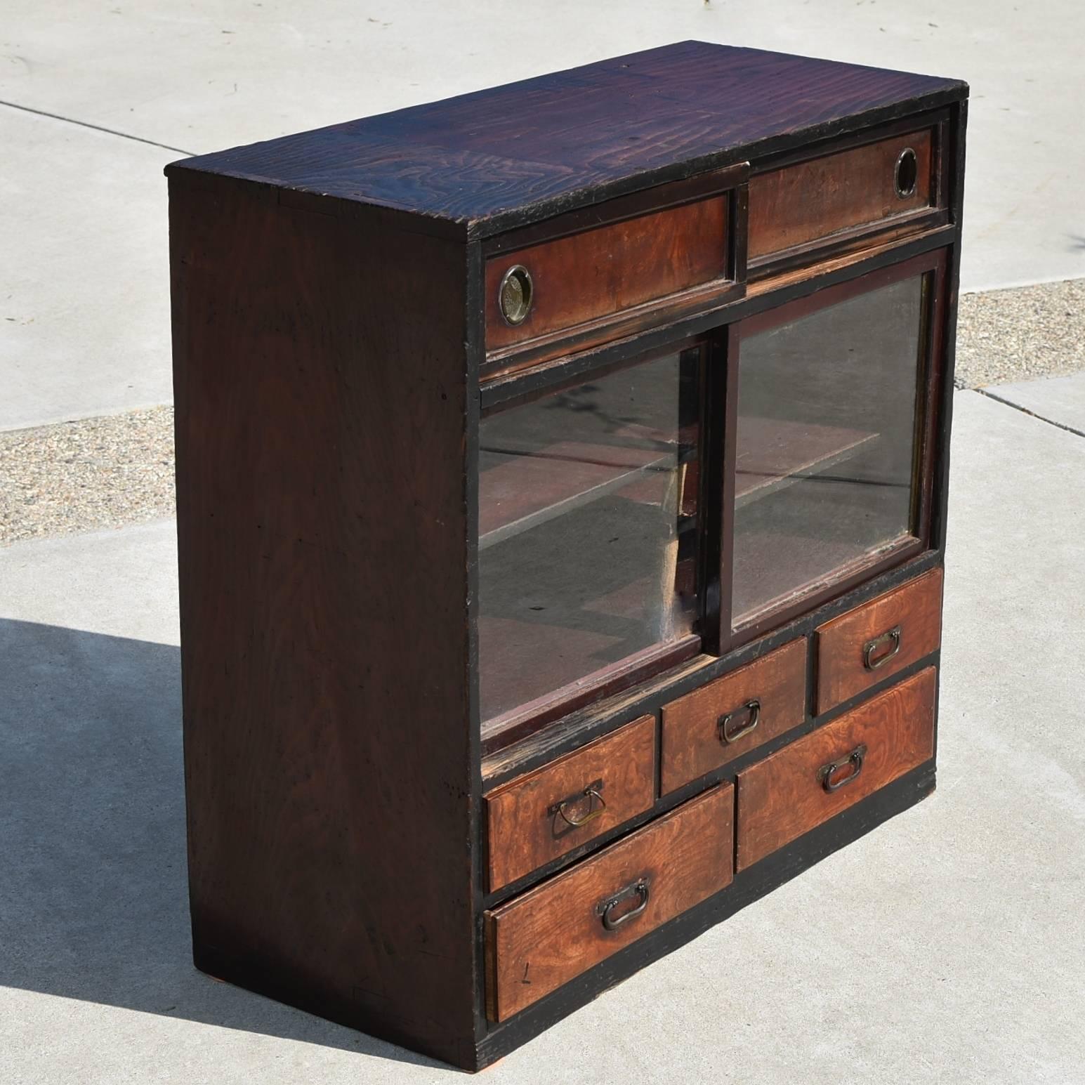 This beautiful chest, albeit its size, features five drawers, two shelves and a compartment behind sliding doors. Splendid burl wood make the drawer fronts while the Classic Japanese bronze hardware adorn the rest of the chest. The shelves are