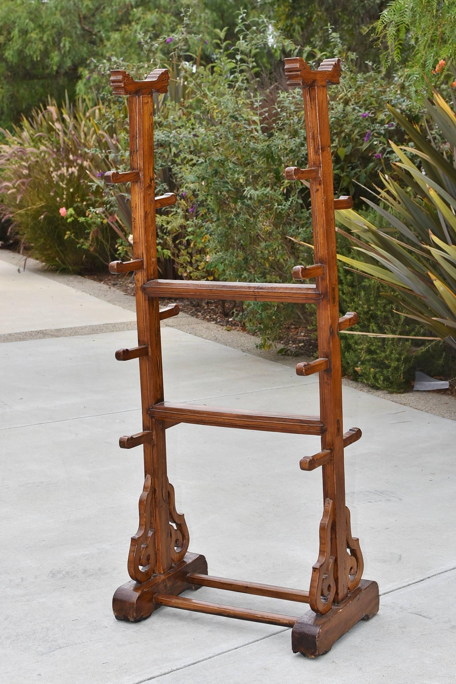 A rare offering. This is a republic era solid wood stand that is designed to hold swords, baton and similar equipment. The stand has stylized dragons on top and its protruding holders. Beautiful curved carvings decorate the base. This is also a