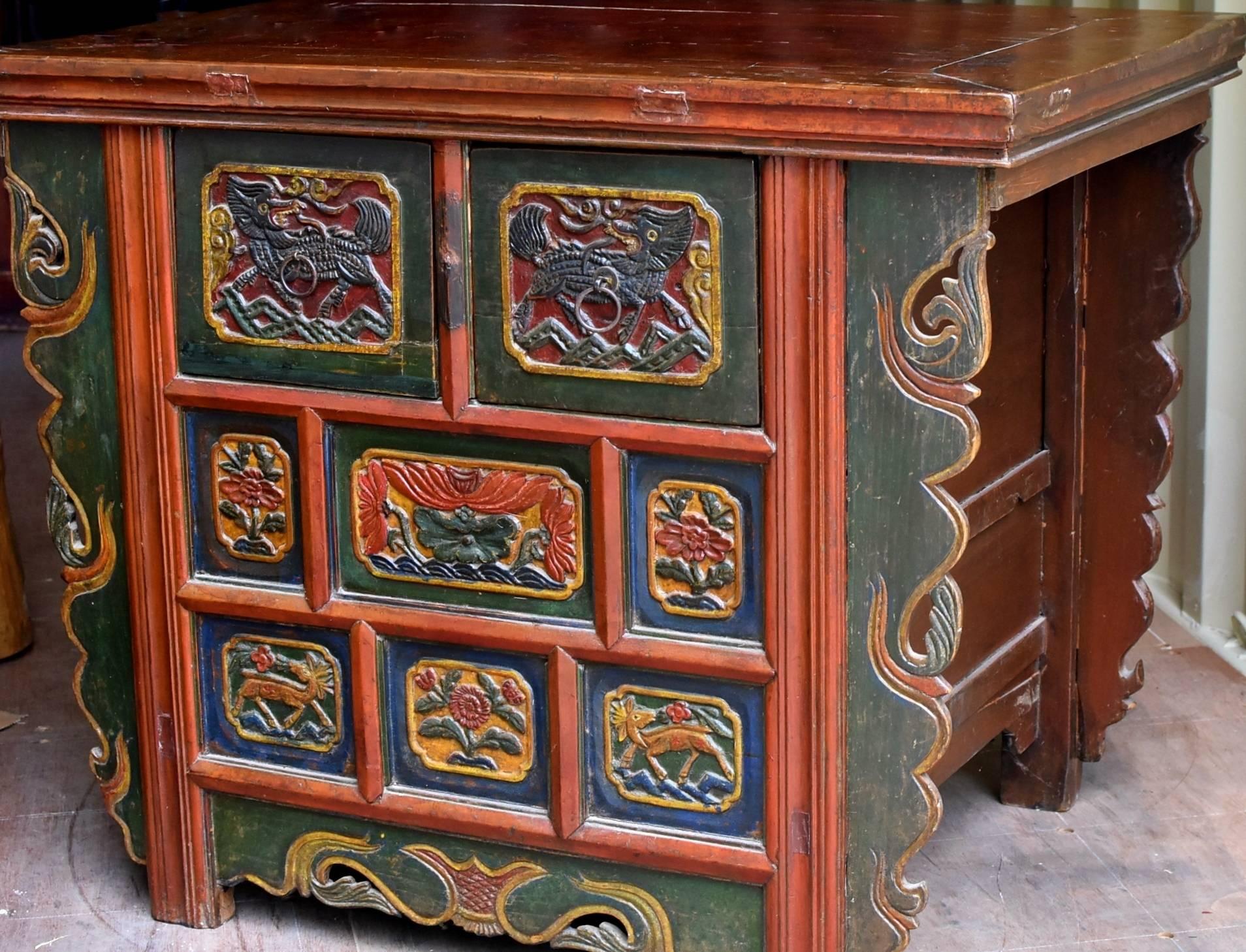 A beautiful, exotic chest from Tibet. The chest is hand-painted with mineral colors. The blue originally came from the gem stone lapis lazuli. The images are hand-carved depicting Qi Lin, the auspicious mythical animal. Lotus and peony symbolize