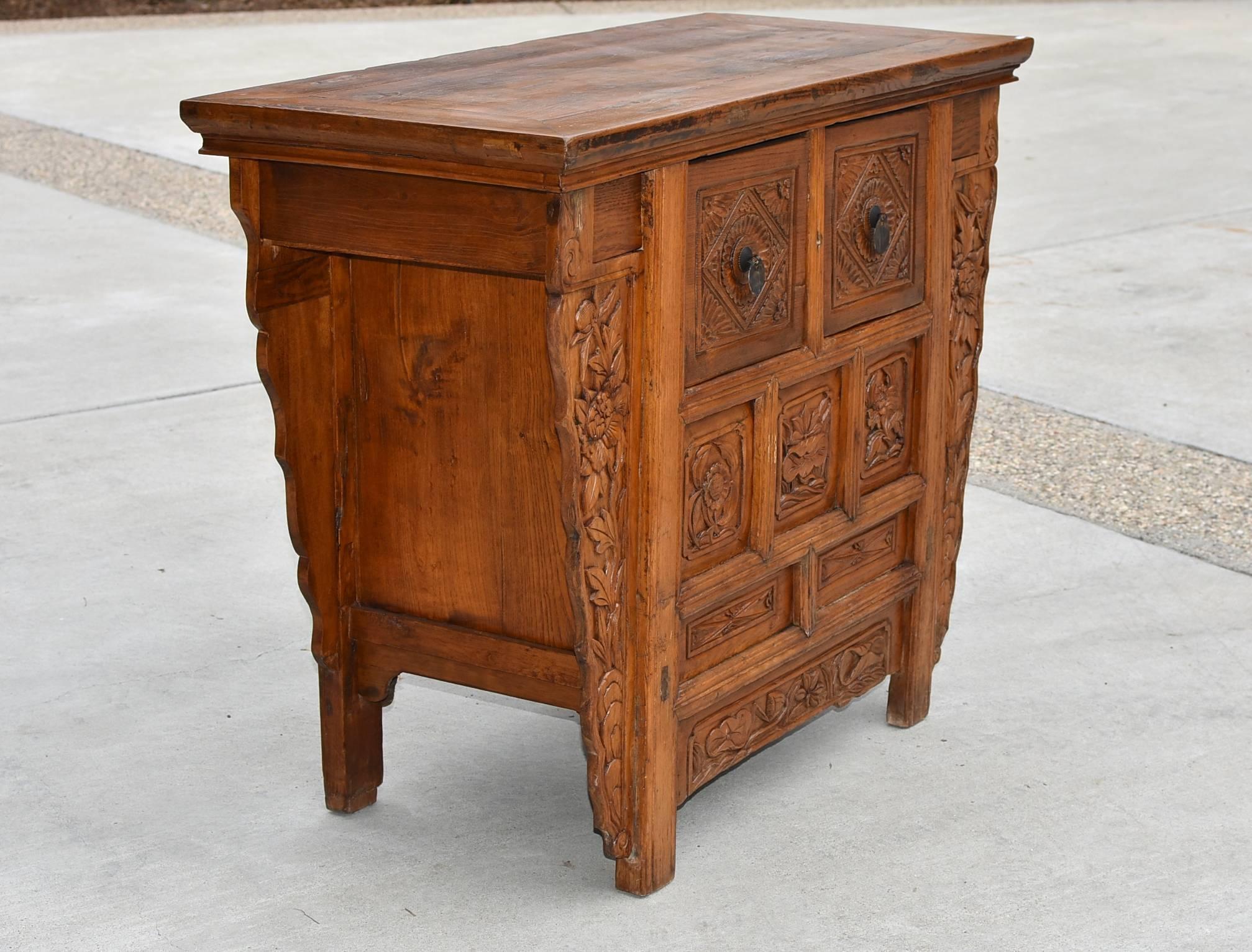 This rustic piece is from Northern China. It has carvings of lotus flowers, sunflowers on the front sides and peonies on the sides. They symbolize peace and good fortune. The carvings are of the typical northern style, which is chunky and rustic.