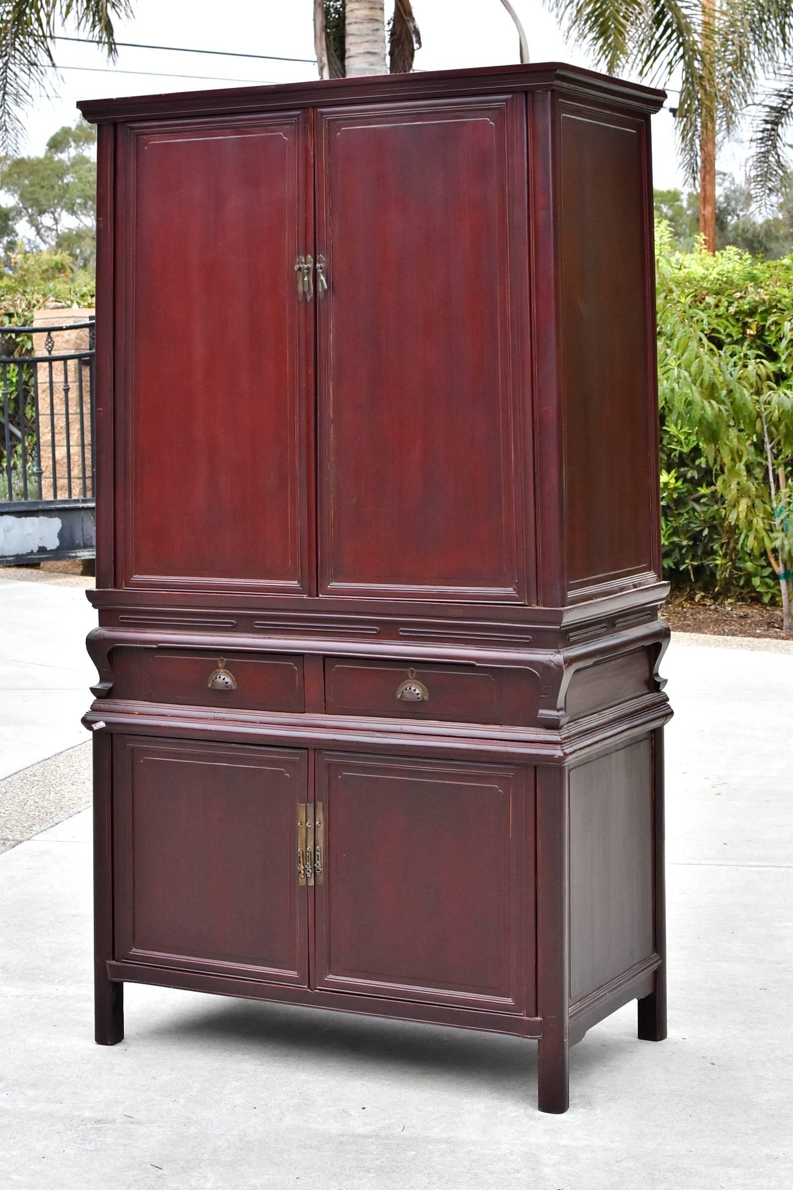 A special two-tiered cabinet. The finish is a beautiful deep plum color. The carvings are delicate, simple and graceful with thin, elegant lines and subdued ruyi motifs carved on the corners. The two tiers separate and can be used individually. This