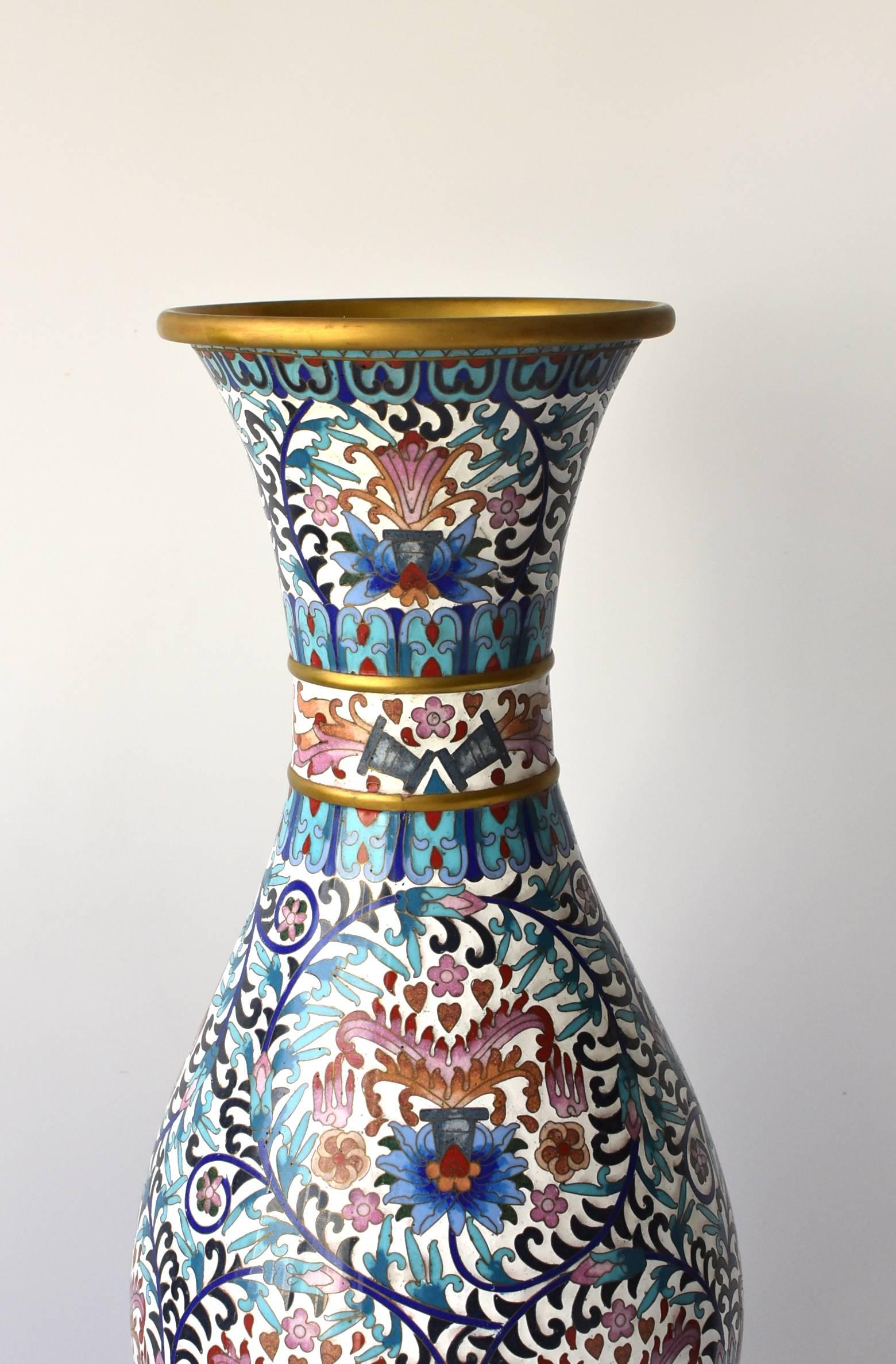 An extra large, tall cloisonné vase. The Cloisonné vase comprises in excess of 10 splendid colors. The overall theme is the full blossoms of peonies, which symbolize great prosperity. Other auspicious symbols include citrons for blessings, lotuses