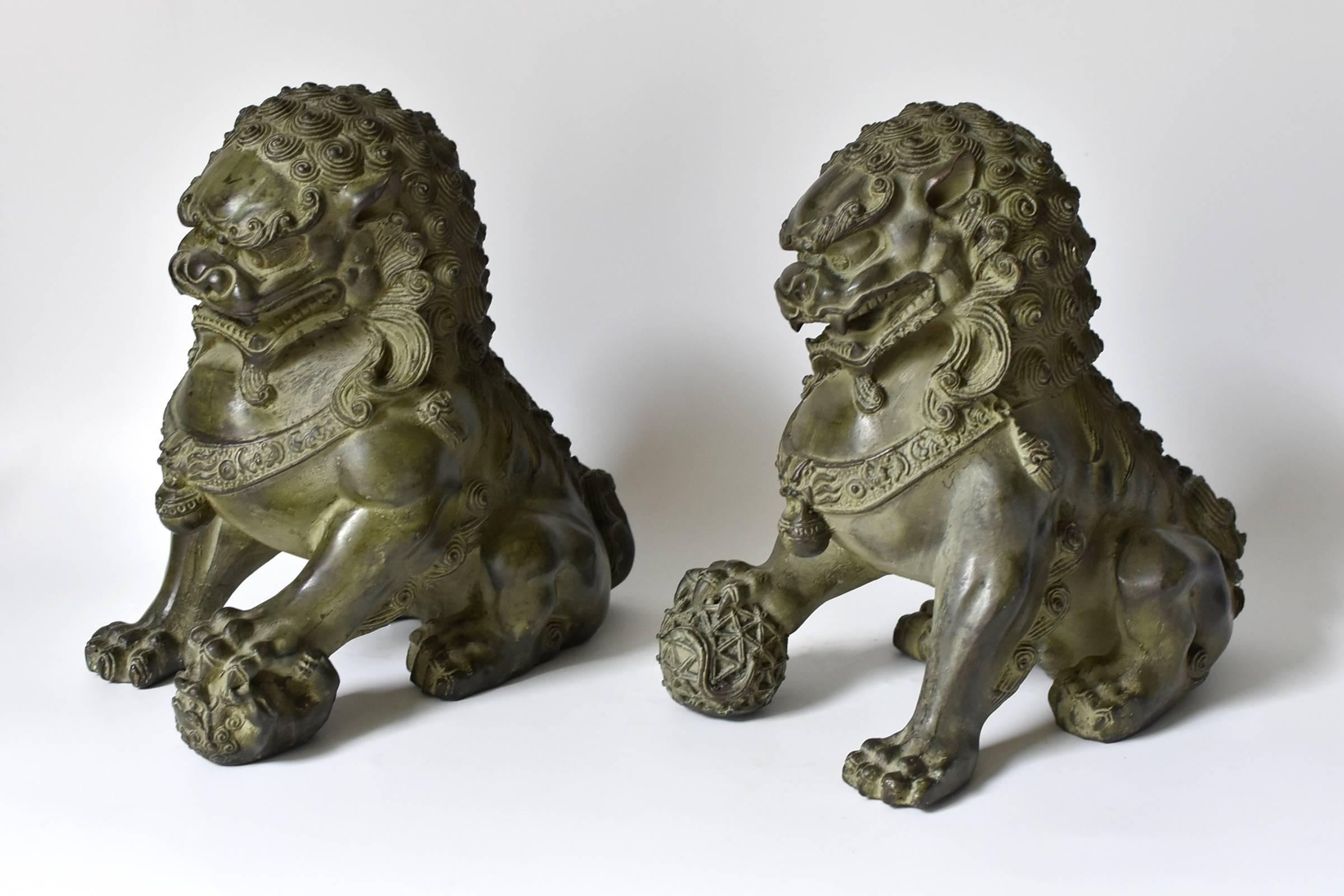 This is a pair fantastic, larger than usual foo dogs. These pieces are very fine with every parts of the foo dogs well defined. The male holds a globe firmly in his paw, symbolizing the universe, while the female holds a cub in hers, symbolizing