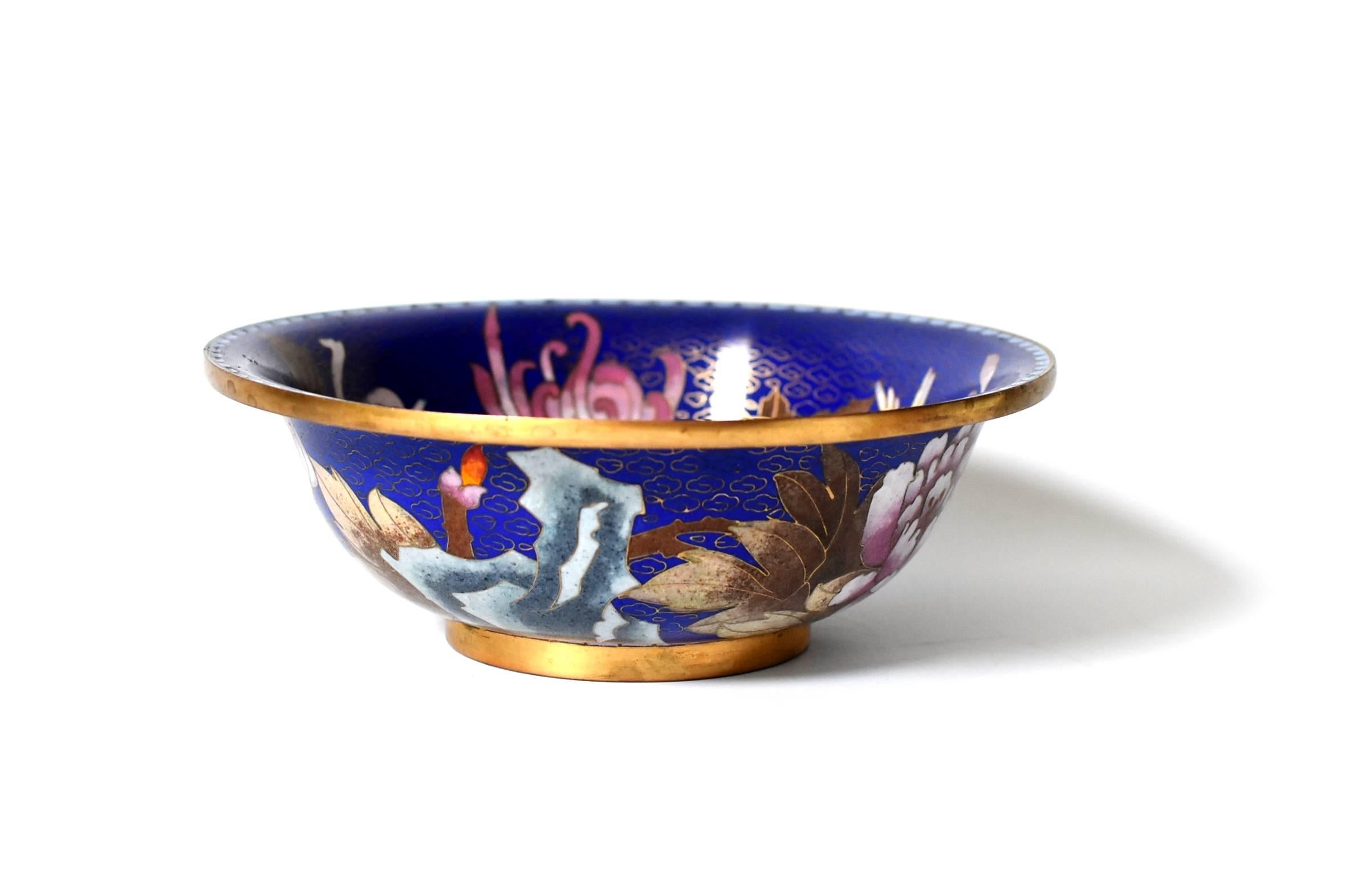Absolute beautiful cloisonné bowl with the purest lapis blue color base. Pink chrysanthemums and peonies, canary bird, grey rocks. The colors are made of natural marble grounded and painstakingly inlaid in the brass perimeters. The beauty of the