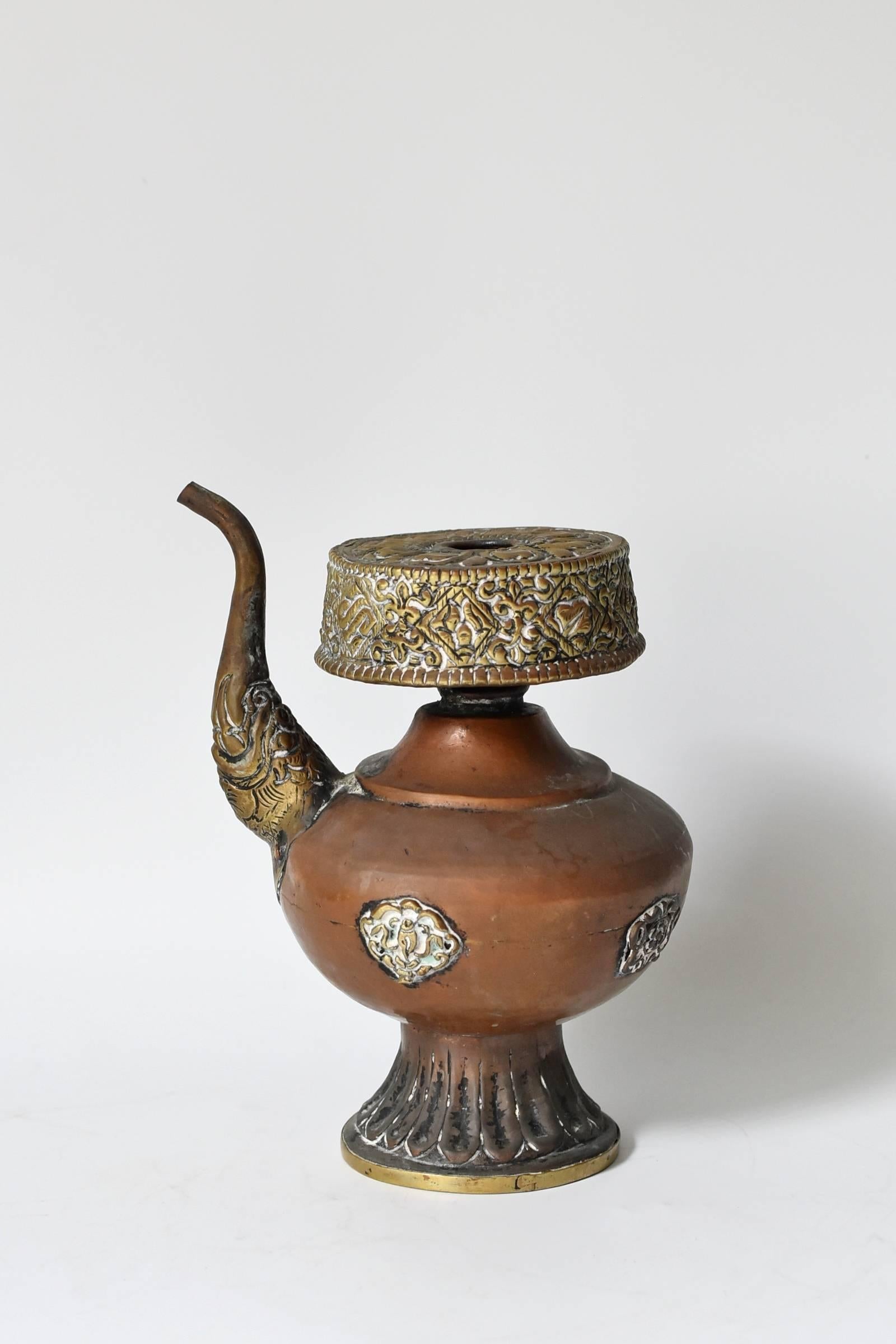This beautiful Tibetan copper pot is used to dispense blessing water. Such a pot, called 