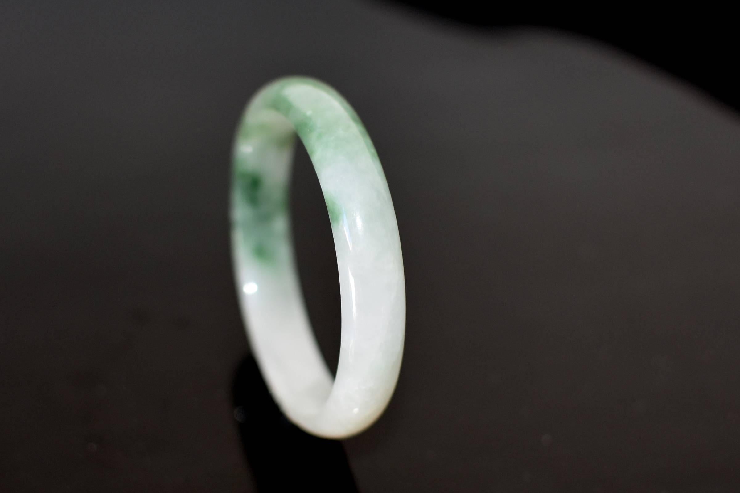 A beautiful, all natural jade bangle. The most lustrous white and romantic fluid moss green combine into one gorgeous color. Beautiful translucency and high gloss. The bangle is perfectly smooth and luxurious to touch. The inside is flat rather than