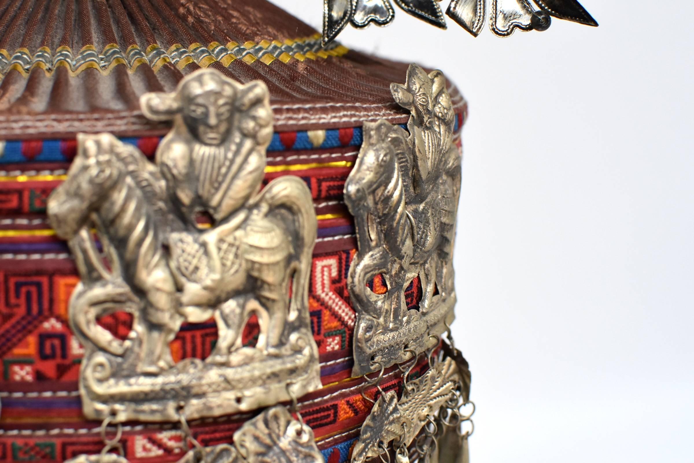 A special Chinese tribal hat made with handwoven tapestry and decorated with beautiful silvered ornaments. The amazing elaborate ornaments consist of multiple flowers and pair of birds, all hand made from silvered metal. The main 
