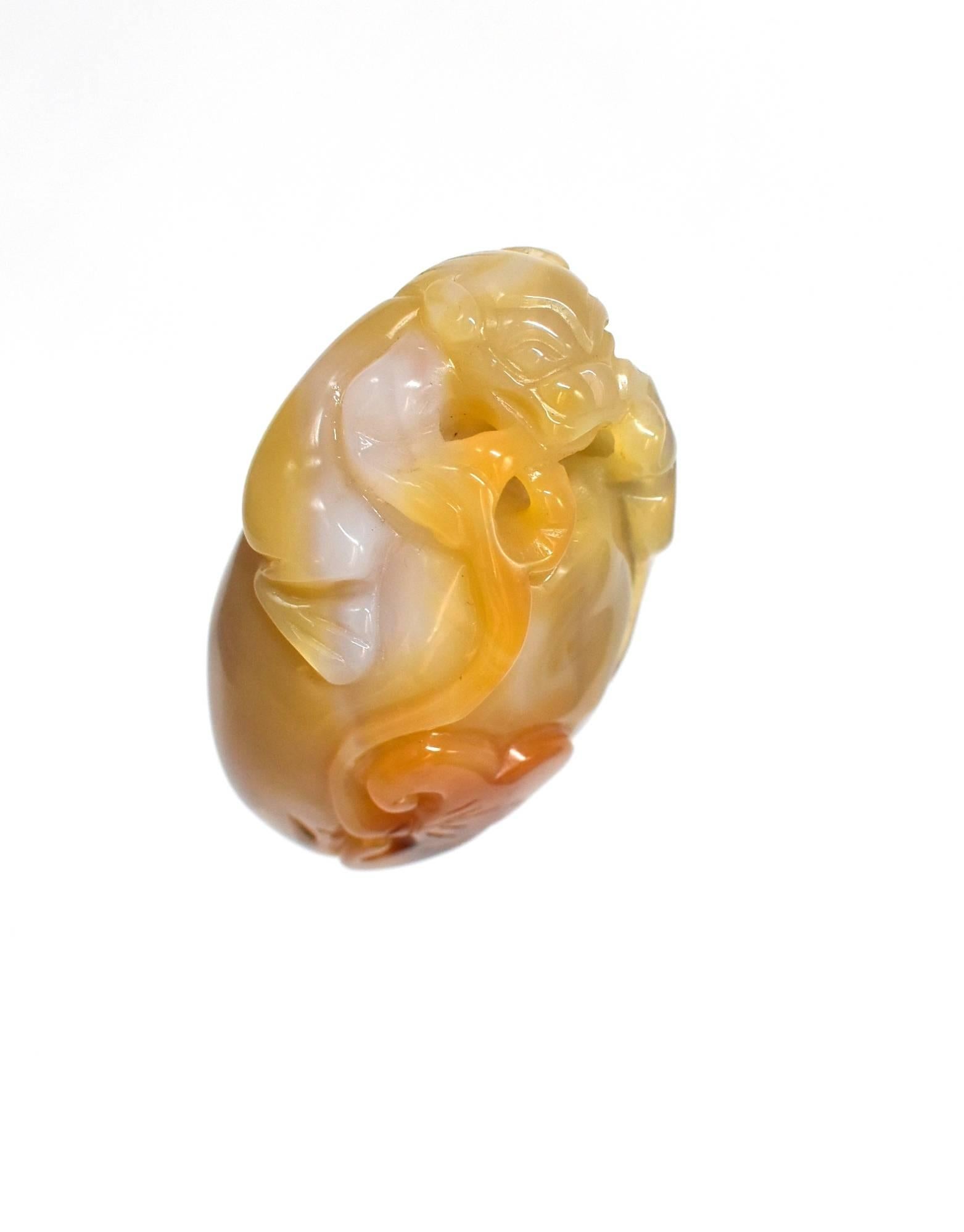 A fine agate sculpture in a hand held form. The piece features a finely carved dragon perched on a rock. The rounded rock has a grown Ling Zhi, which is a symbol of good health and longevity. The agate is perfectly smooth and pleasant to touch and