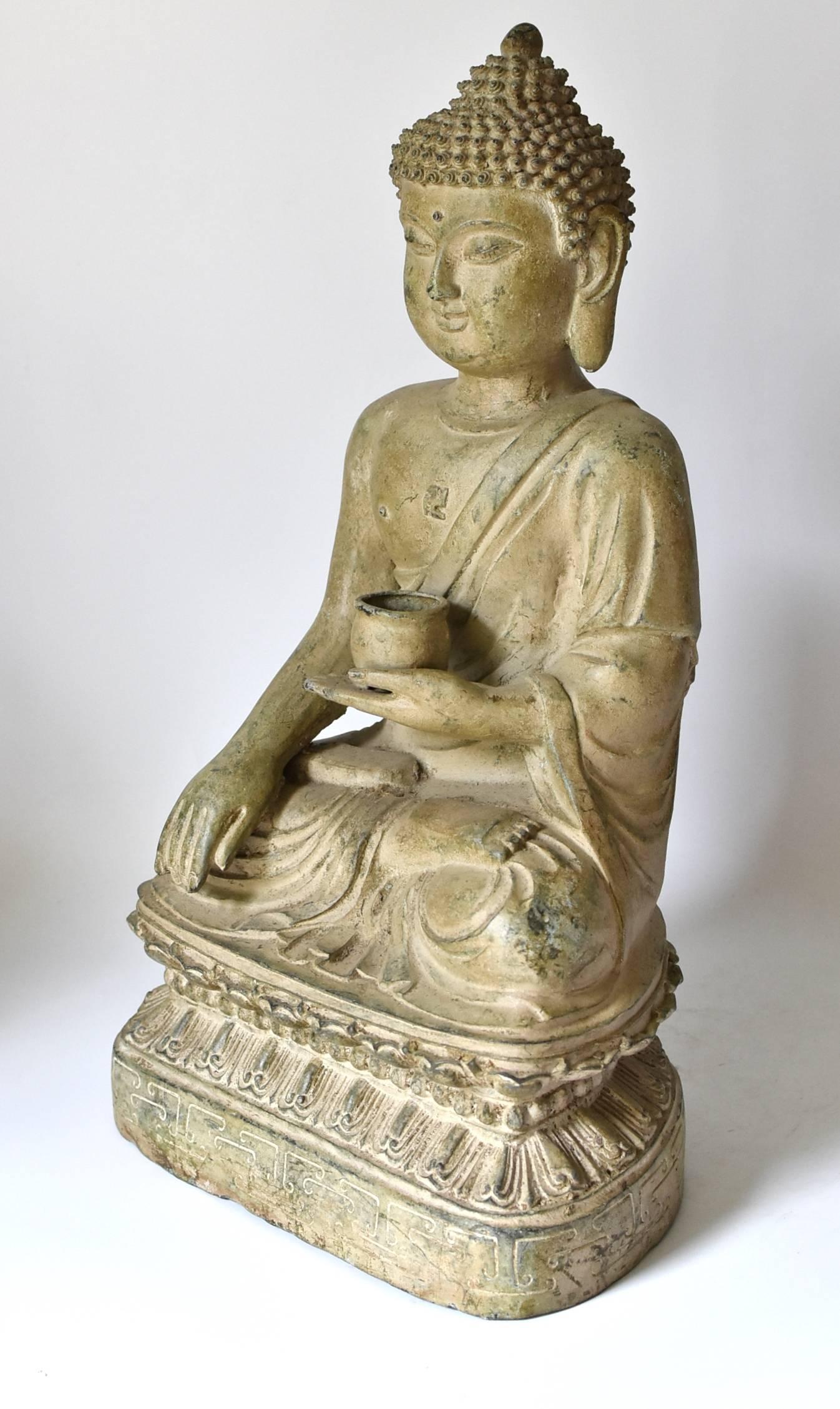 A beautiful pale green bronze sitting Buddha statue. The style of the piece is of the Tang dynasty era, with a full face, long ear lobes and scrolled hair style. Beautiful, finely defined facial features convey a sense of calm and serenity. Buddha