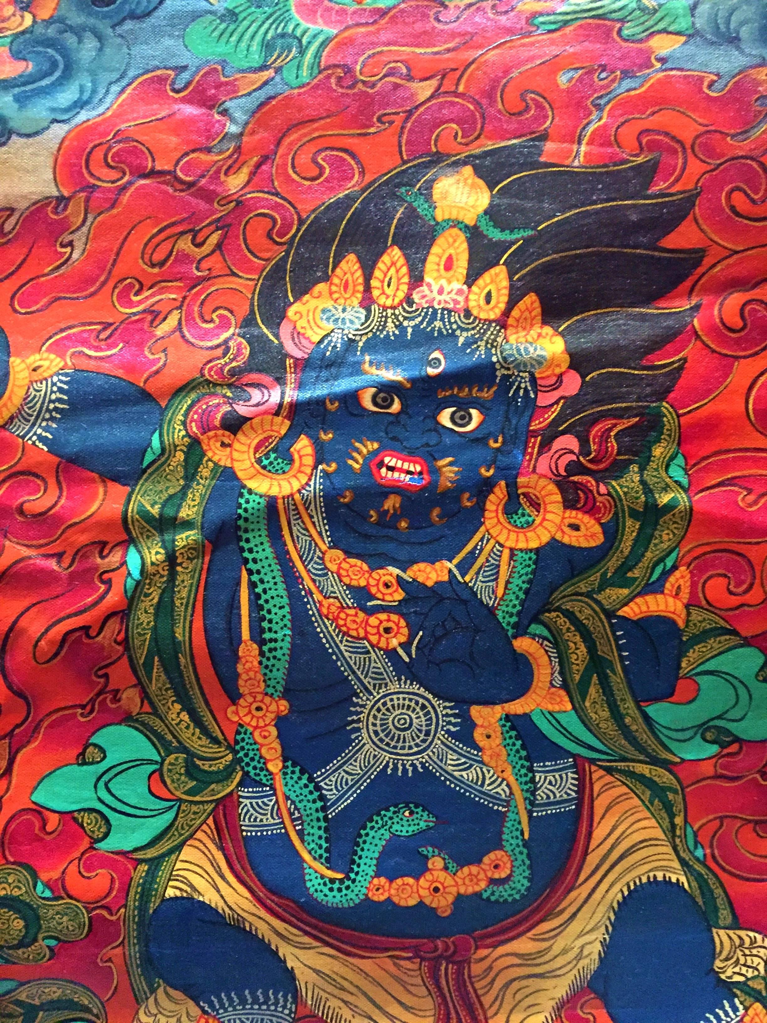 Our Tanka is painstakingly painted by Tibetan artists. Tanka depicts the protection god Dorje Drolo whose ferocious expression subdues negative and demonic forces. Comes with its own protective cover in sheer green organza.