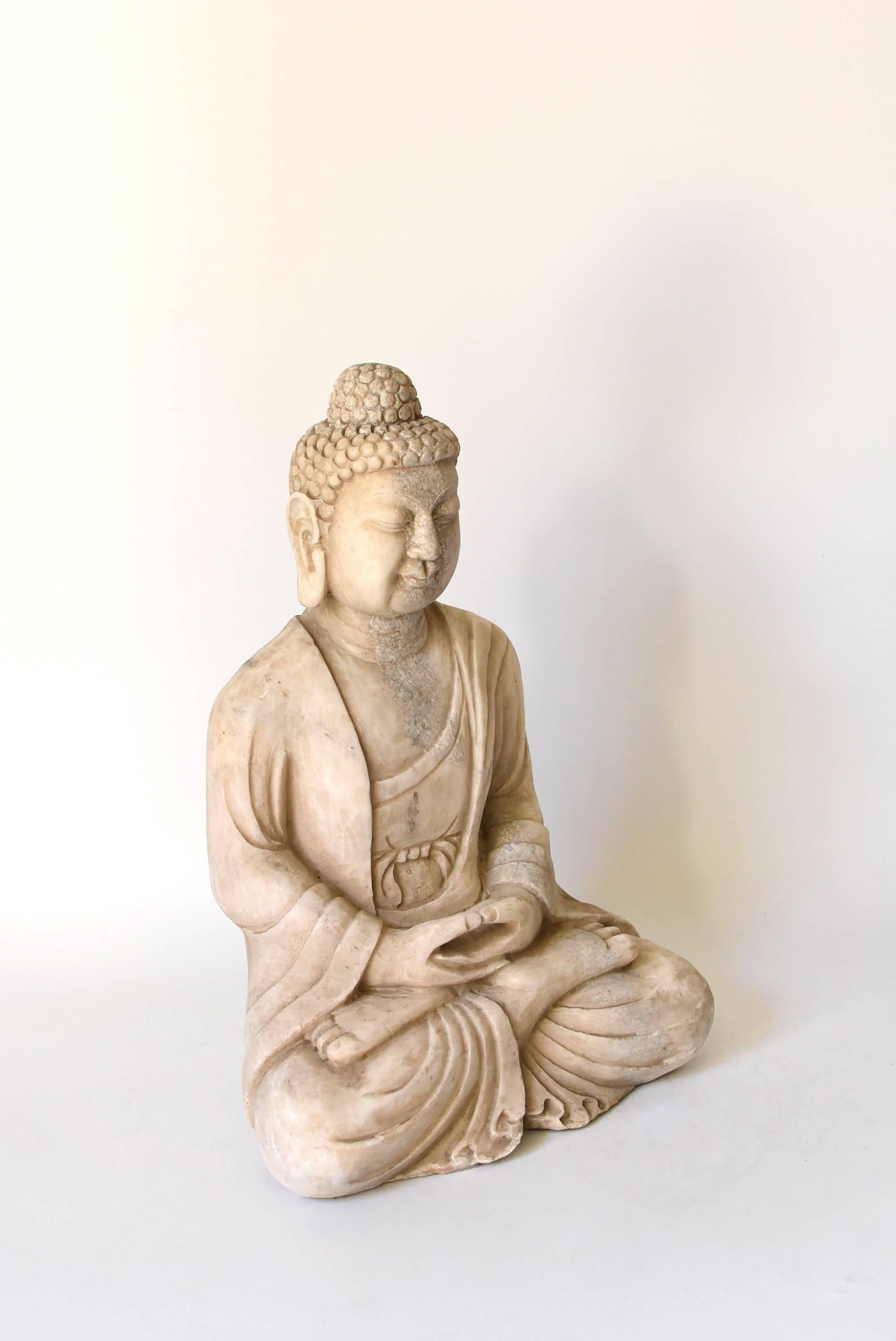 A beautiful Buddha statue hand-carved from solid marble. His facial expression and robe are well defined. Large earlobes and full face are features of Tang dynasty style. Buddha's special mudra with his fingers forming a circle expresses uniting the