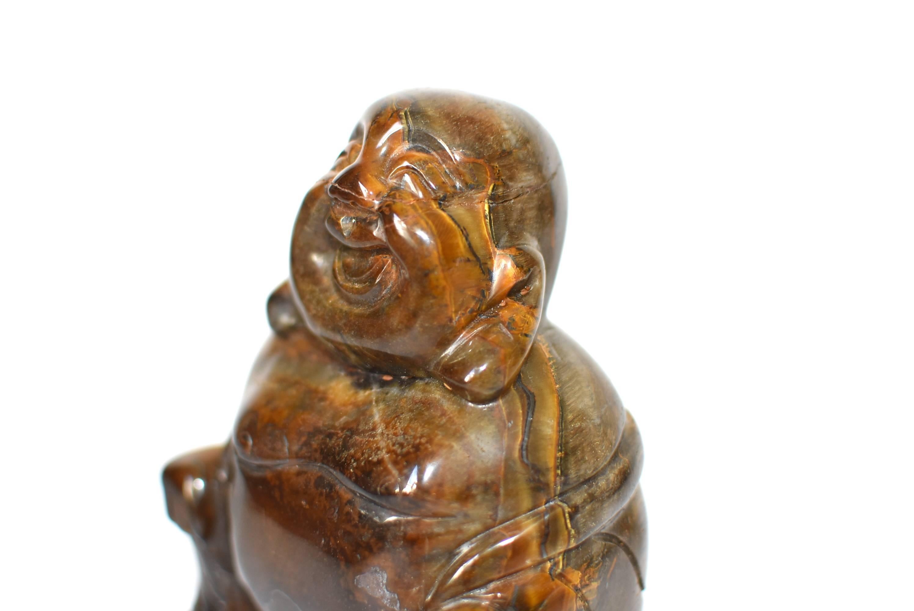 A beautiful natural tiger's eye sculpture depicting the Happy Buddha. This entire sculpture is made of one piece of the finest quality tiger's eye that weights 1.4 lb with fantastic iridescence. One of a kind. Tiger's eye is believed to enable clear