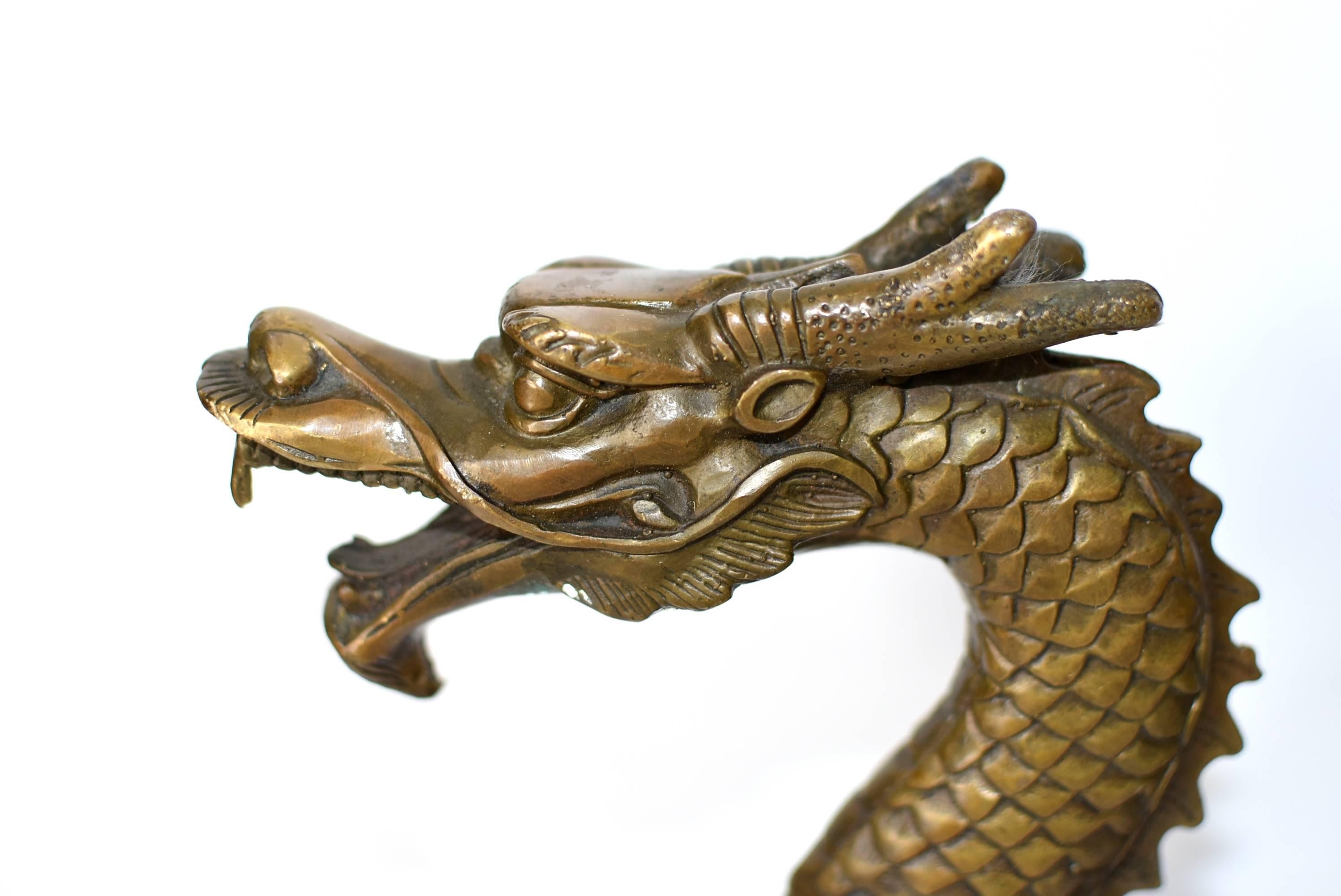 A very large brass dragon. The dragon is the most important symbol in Chinese culture. A sign used by the Emperors, it represents power, leadership and prosperity. This wonderful large sculpture captures the dragon in motion. Fine details of scale,