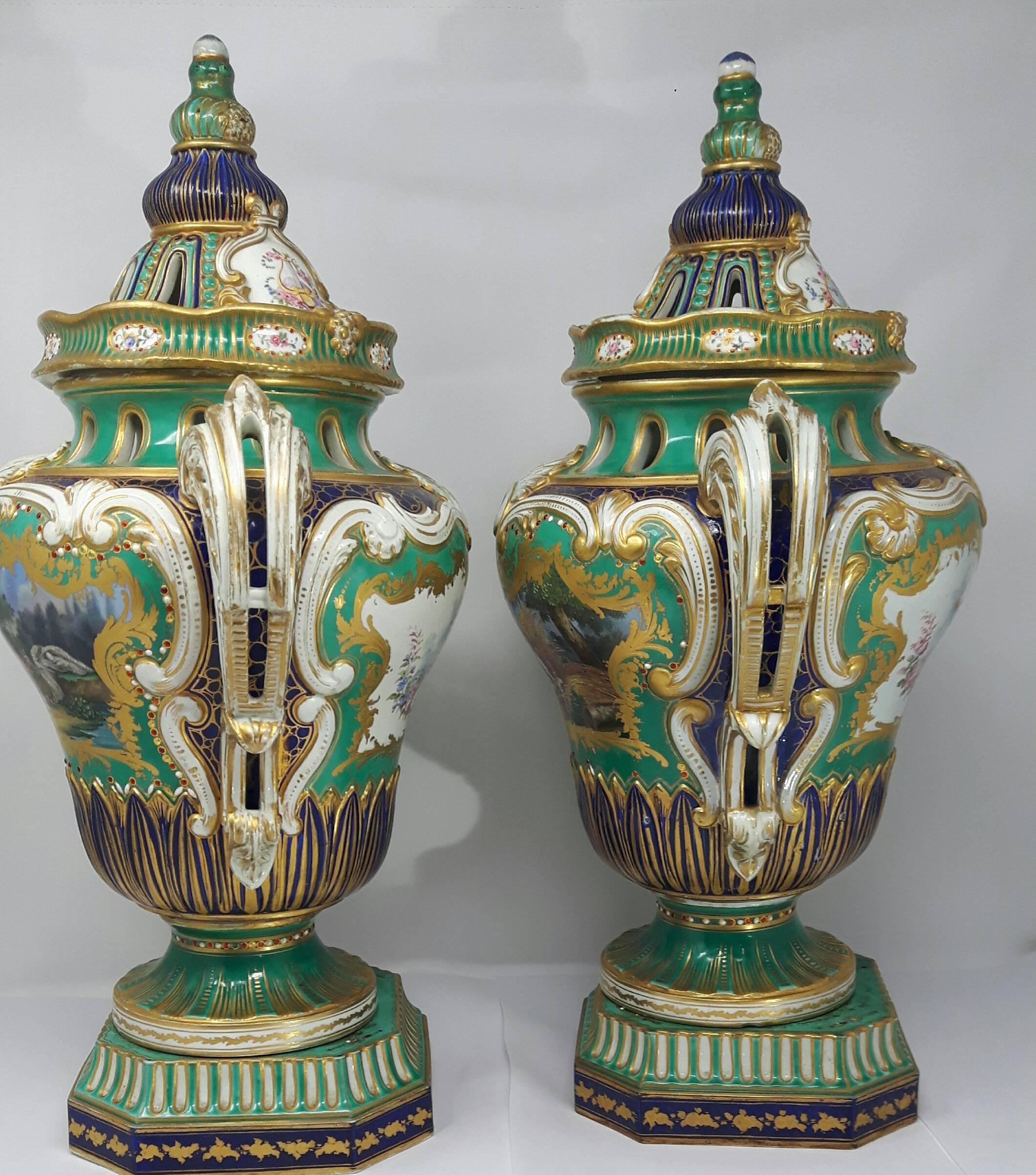 A monumental pair of sever vases. Each vase beautifully painted with scenes of classical figures and exotic birds against a pale green and cobalt blue background.