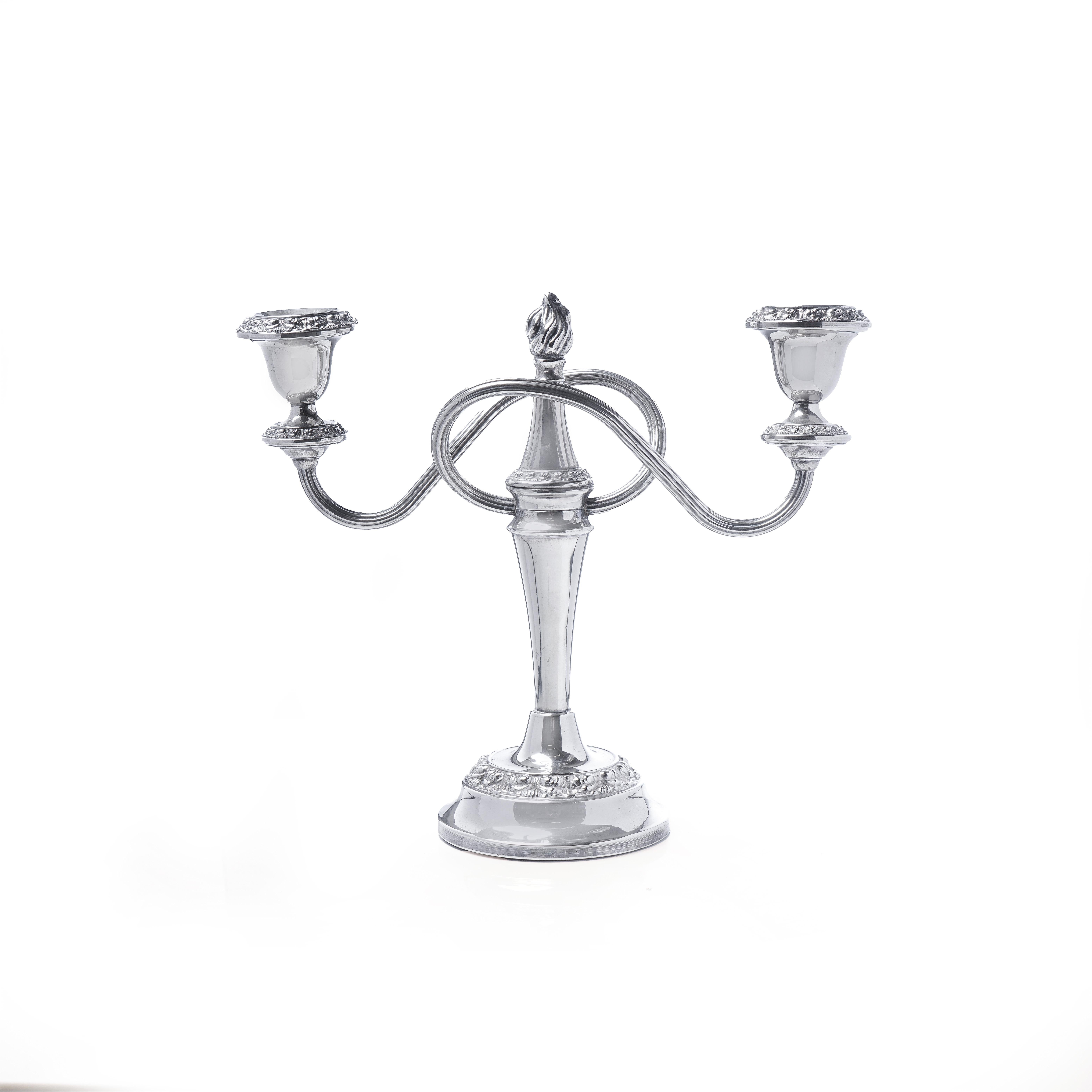 Una coppia di candelabri antichi placcati in argento finemente lavorati, ciascuno con due rami di candele a spirale che si irradiano da una colonna centrale. I candelabri sono progettati in stile neoclassico e presentano un terminale a fiamma