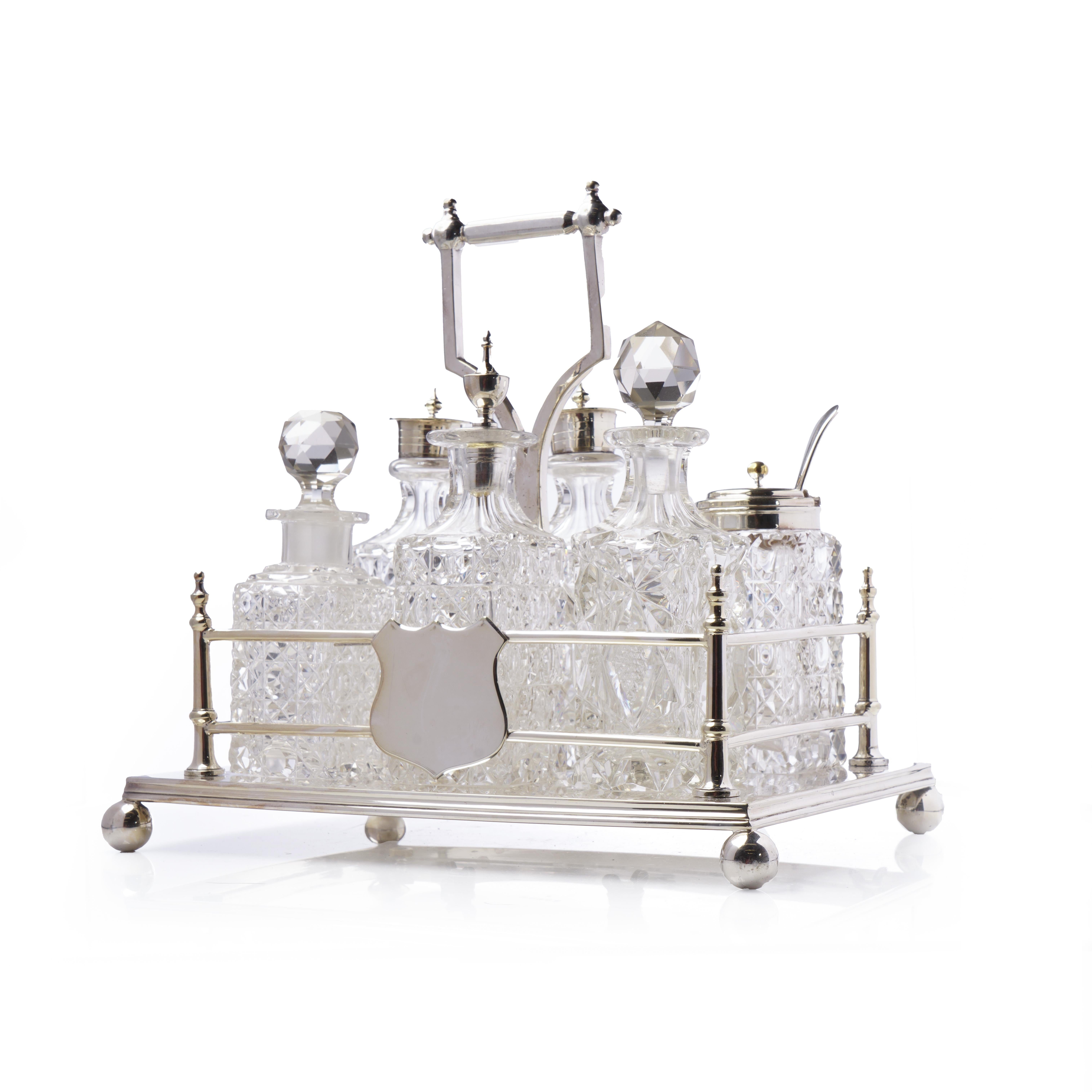 Un magnifique ensemble de burettes anciennes comprenant six bouteilles à condiments en verre finement taillé, logées dans un support orné en plaqué argent. Les bouteilles présentent des motifs de coupe variés et sont surmontées de bouchons assortis