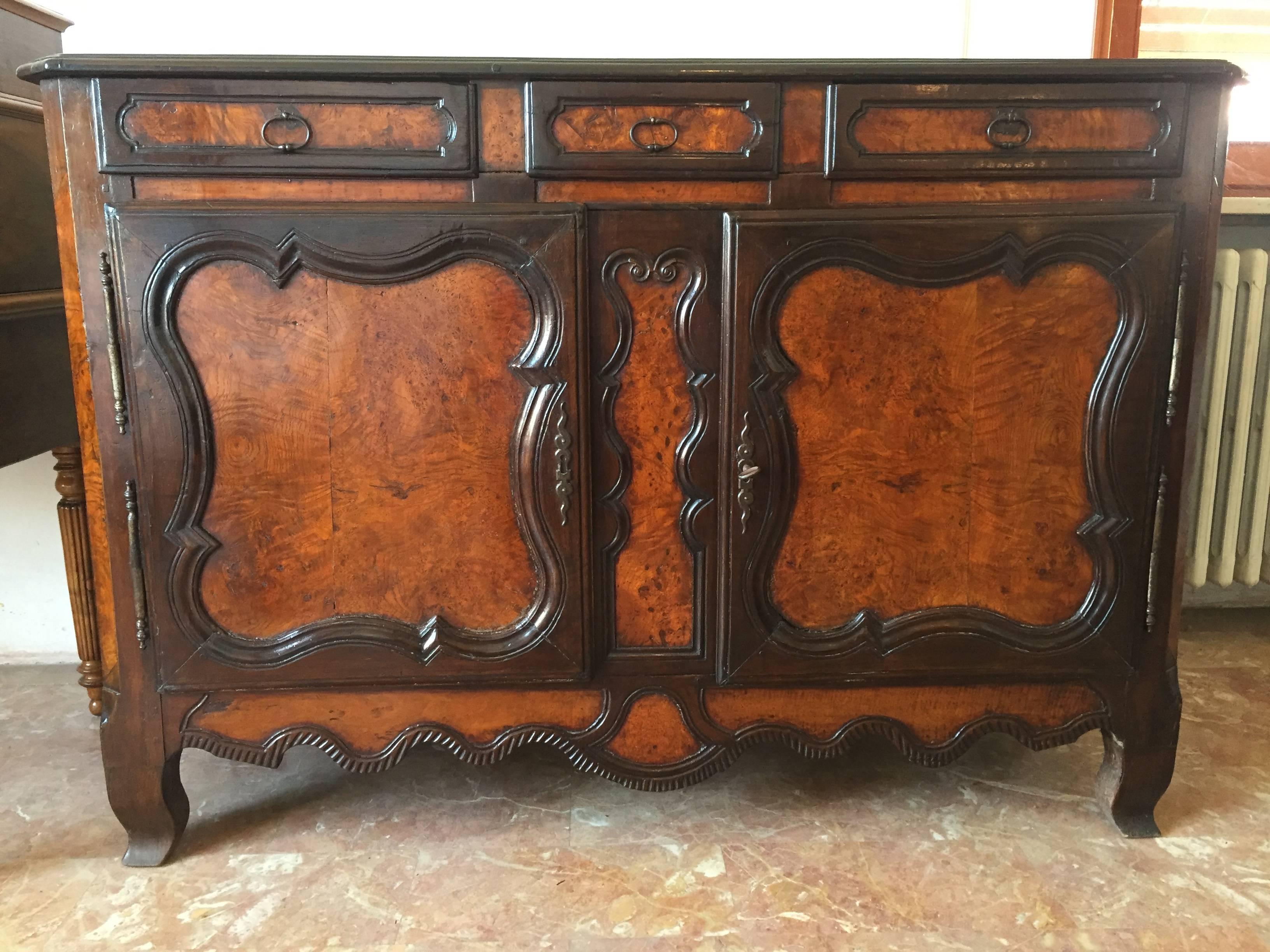 Beautiful buffet with carved doors and wavy apron.
It was built in France, area of Bresse with different kind of wood, fruitwood and
elmwood to create two toned and two textured effect that is unequalled in the world of furniture.
Gorgeous warm