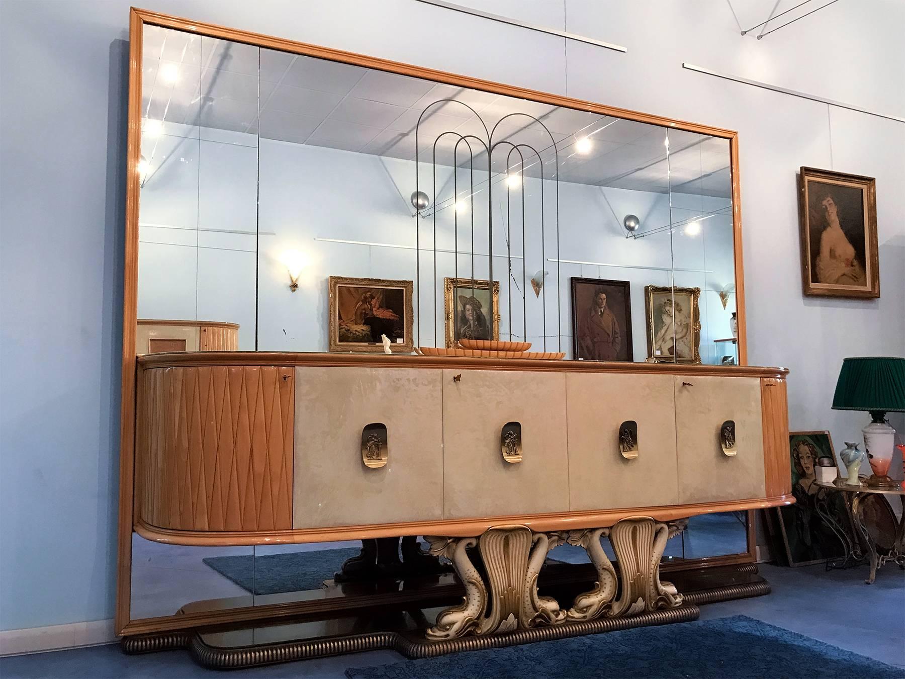 Spectacular mirrored sideboard in parchment and maple designed by Osvaldo Borsani in the 1940s, with splendid movement of the lines on the front, glass top, marble base, insides in maple. Magnificent mirror on the back depicting a spouting fountain.
