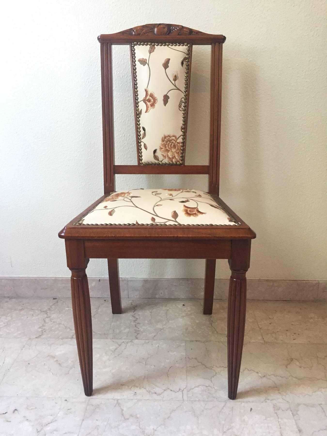 Beautiful French chairs in walnut with decorative inlays on the backs, grooved legs, new upholstery in faux leather with embossed plant motifs.