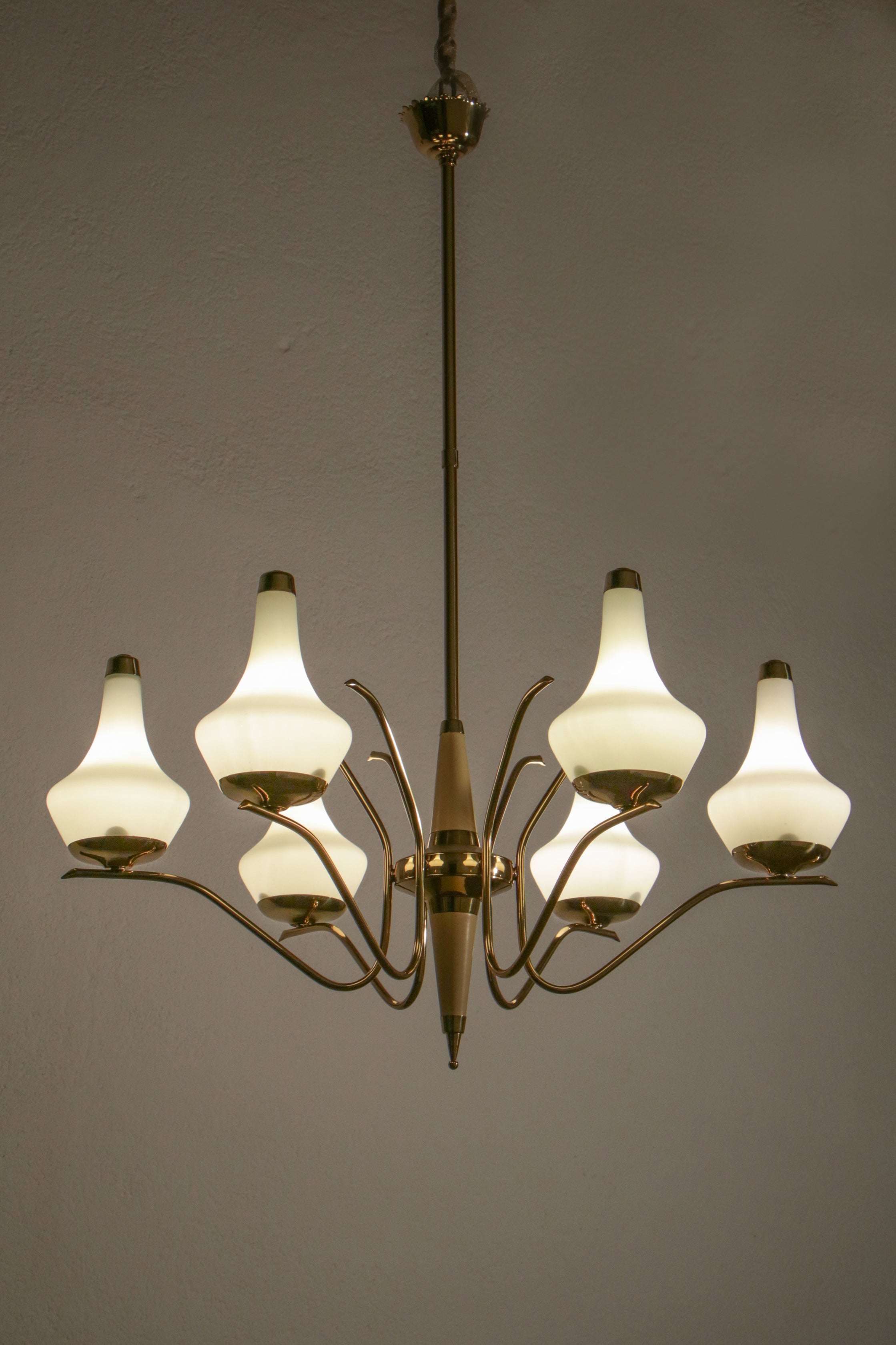 This beautiful Italian gold and ivory color chandelier from the 1950s is attributed to Stilnovo and features polished brass, ivory lacquered aluminum, opaline-coated glass, and six E14 light bulbs. 

The design of the chandelier is truly elegant,