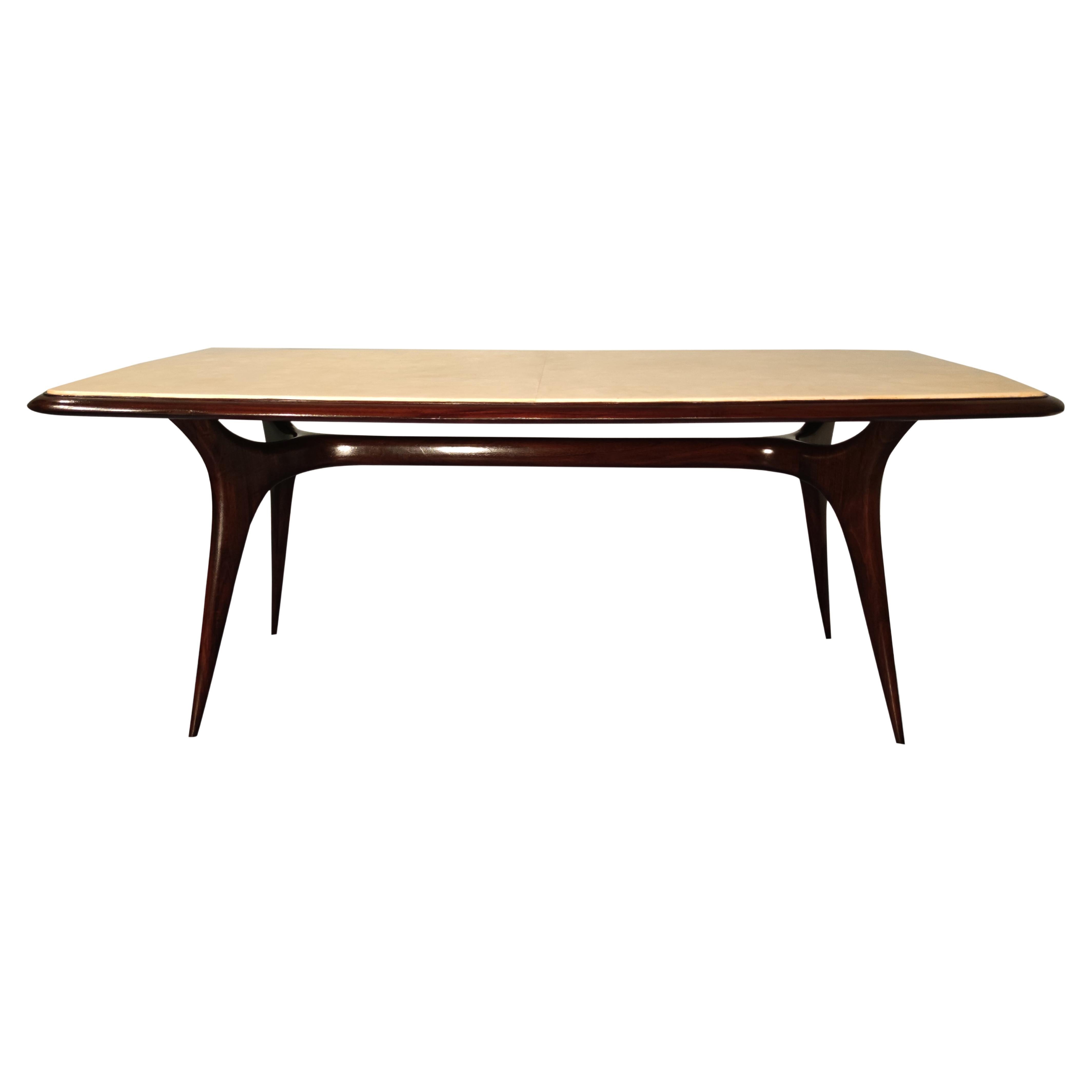 Stylish mid-century dining table attributed to Guglielmo Ulrich, from the 1950s. The top is made of precious parchment paper. The legs line in walnut is a splendid example of the 1950s Italian design. This dining parchment table is in good